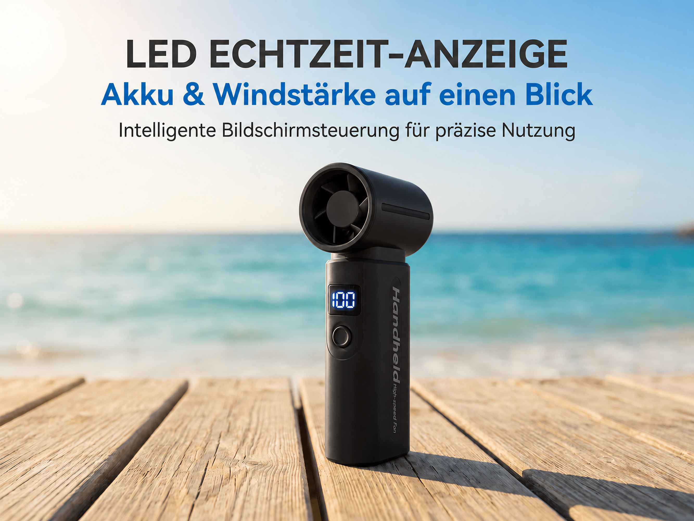 Schwarzer Handlüfter mit LED-Anzeige auf Holzplanken am Strand.