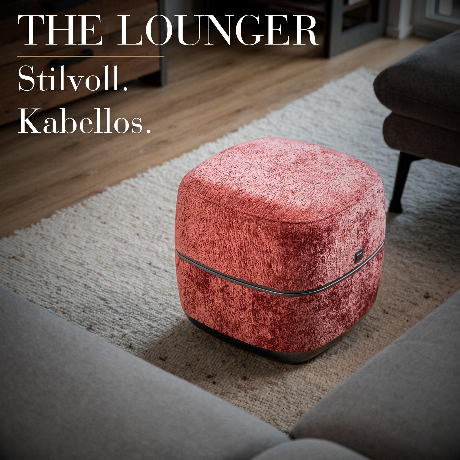 Ein korallenroter Hocker mit Samtbezug auf einem Teppich.