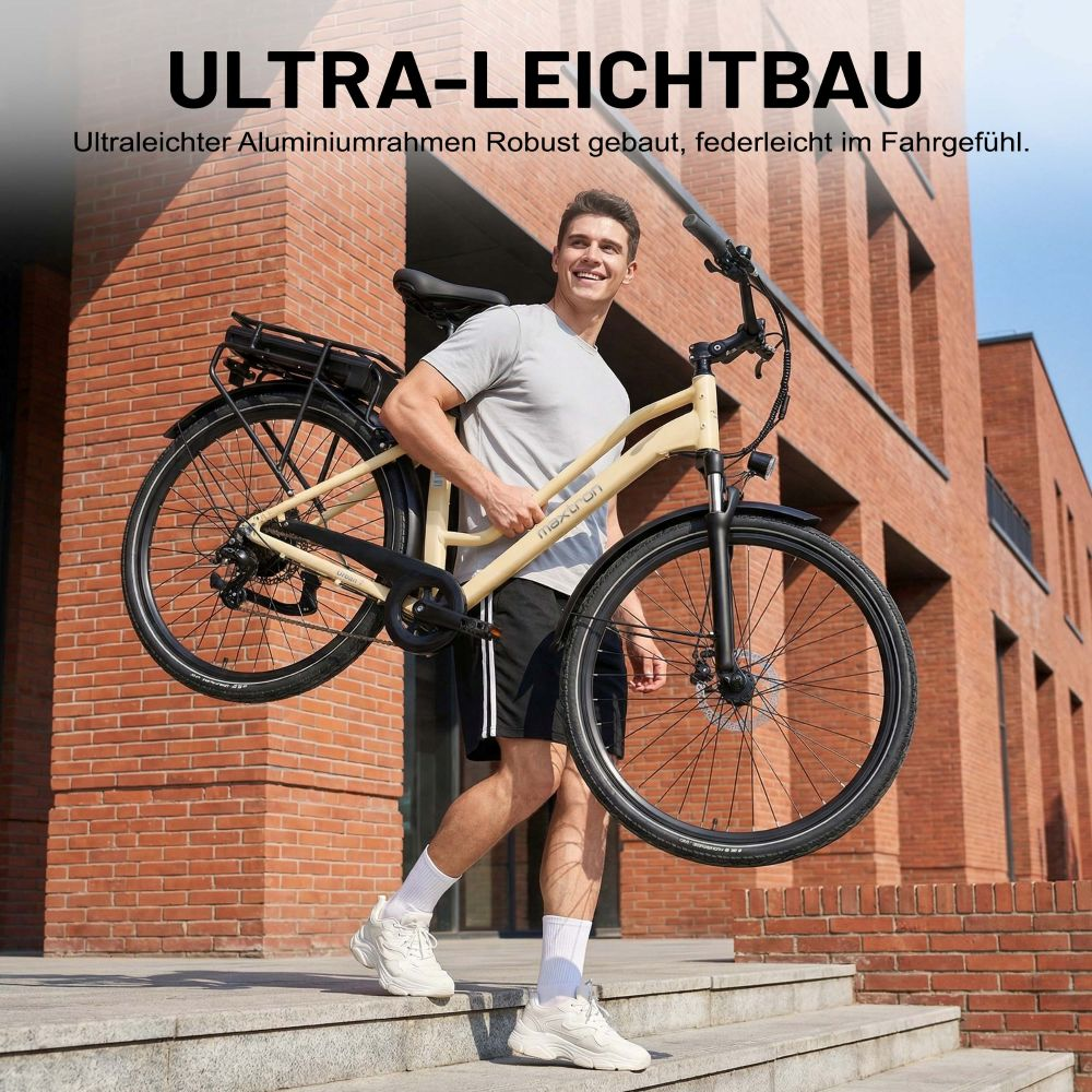 Uomo porta una bici beige chiaro con portapacchi nero davanti a un edificio di mattoni.
