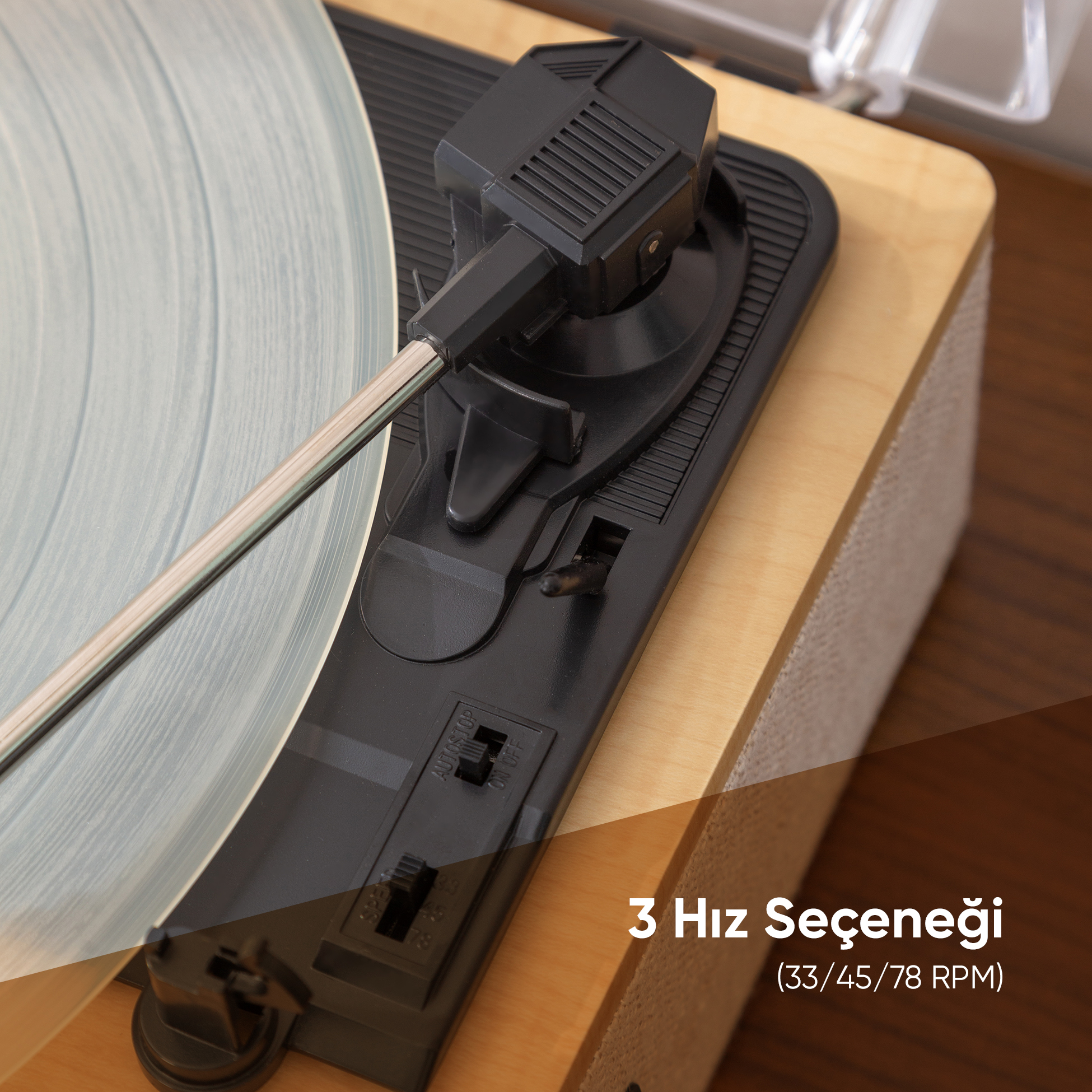 Açık mavi vinil plaklı ve siyah tonearmlı pikabın yakın çekimi.