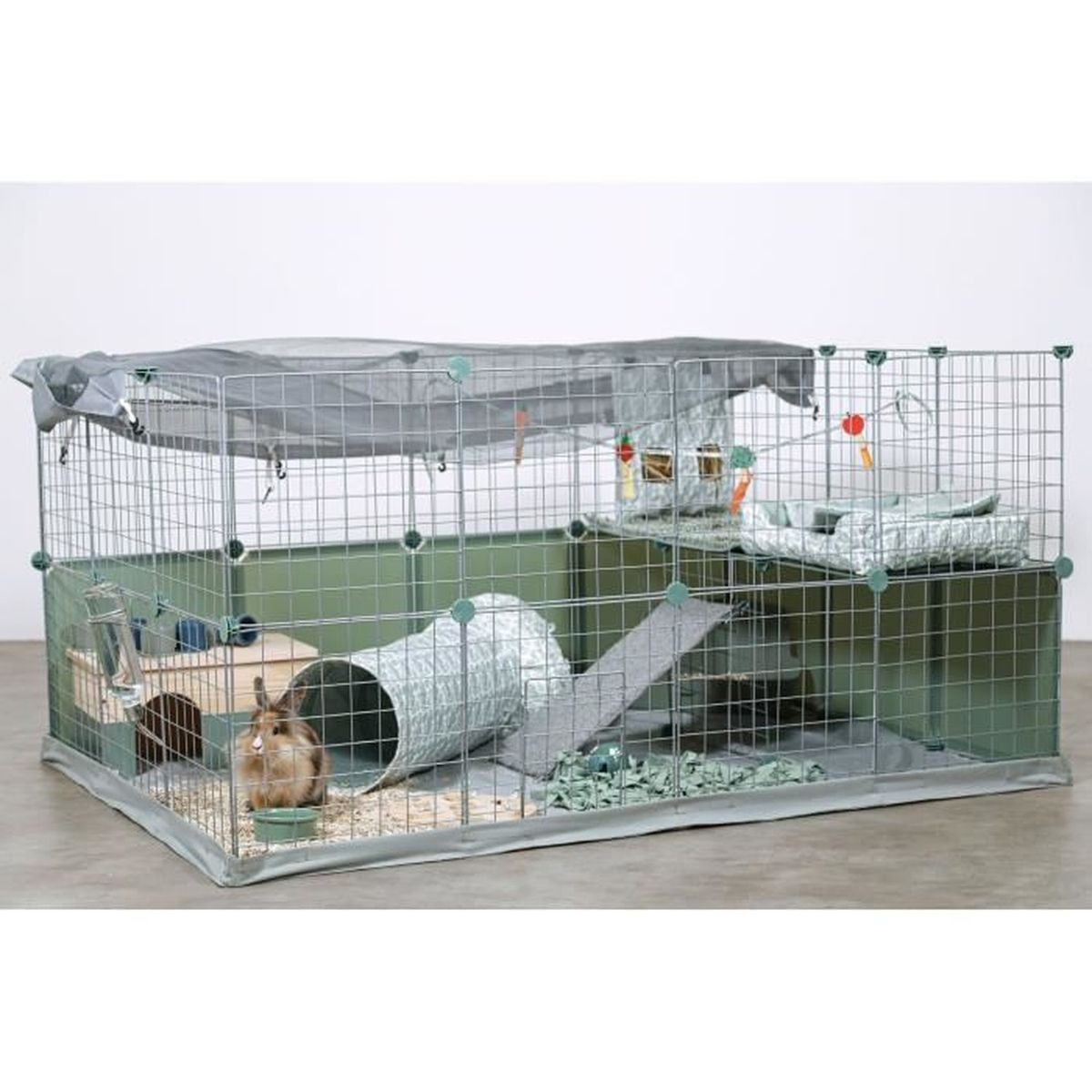 A rabbit sits inside a large, multi-level enclosure with tunnels and ramps.