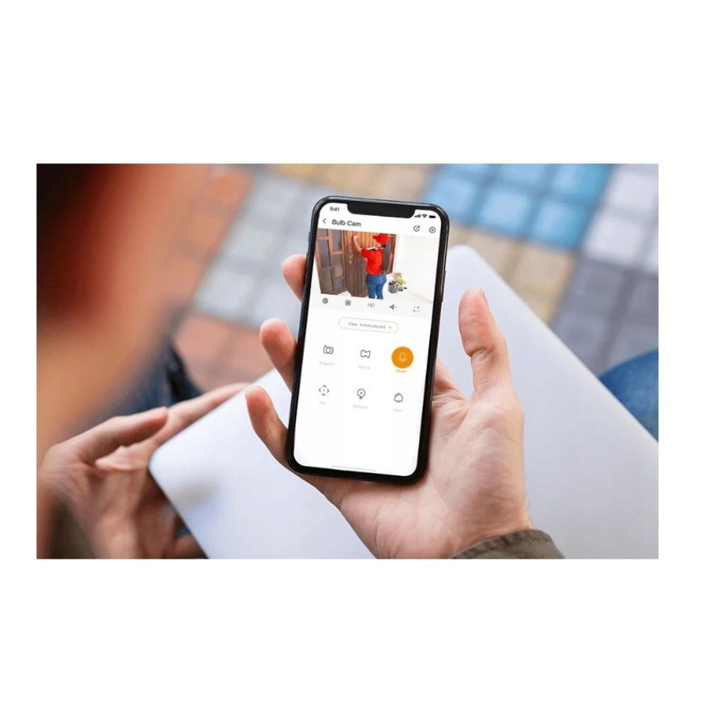 Osoba trzyma smartfon wyświetlający aplikację kamery bezpieczeństwa z podglądem na żywo.