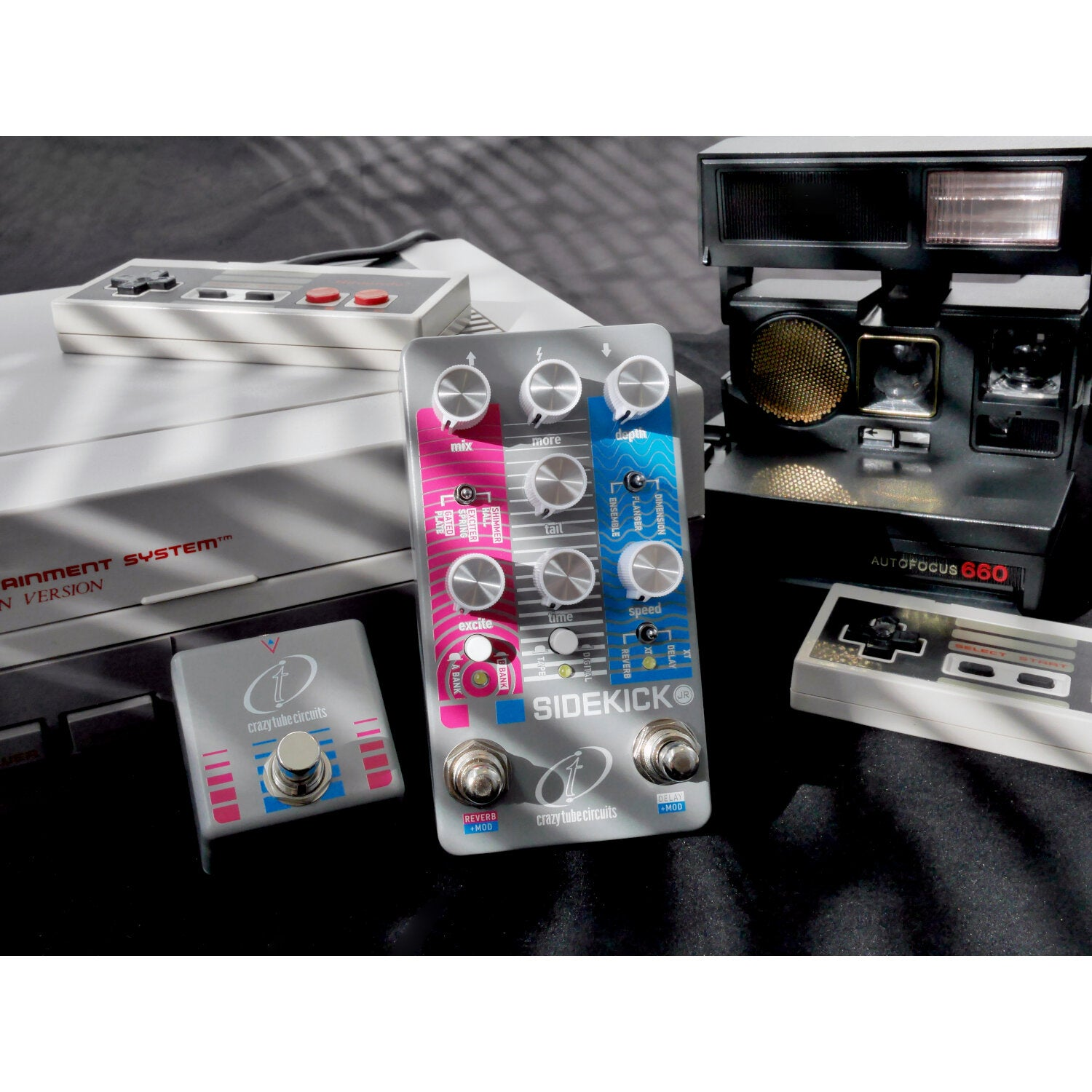 A vintage Nintendo console, controllers, and Polaroid camera sit on a black surface.