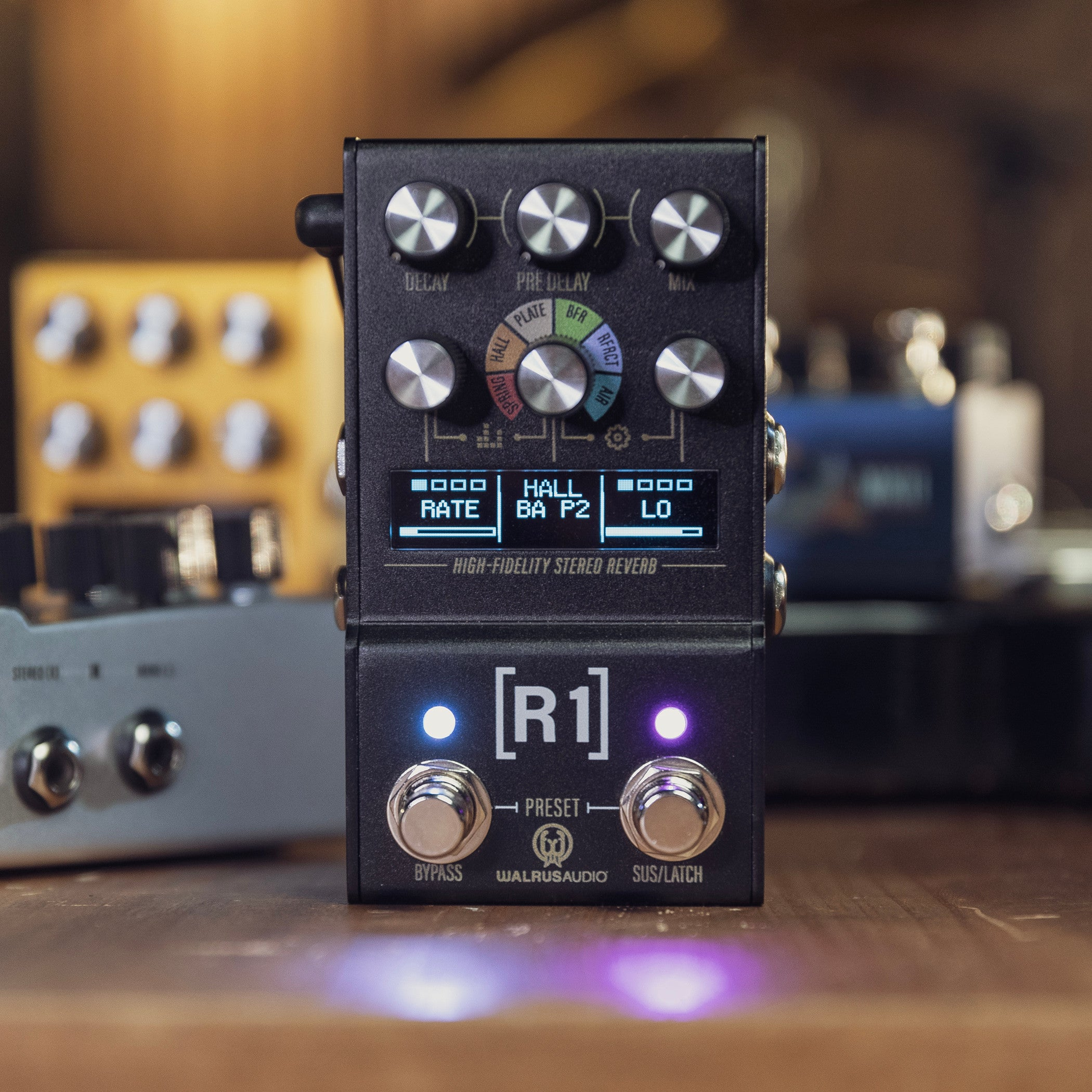 A black guitar effects pedal with knobs and a display screen.
