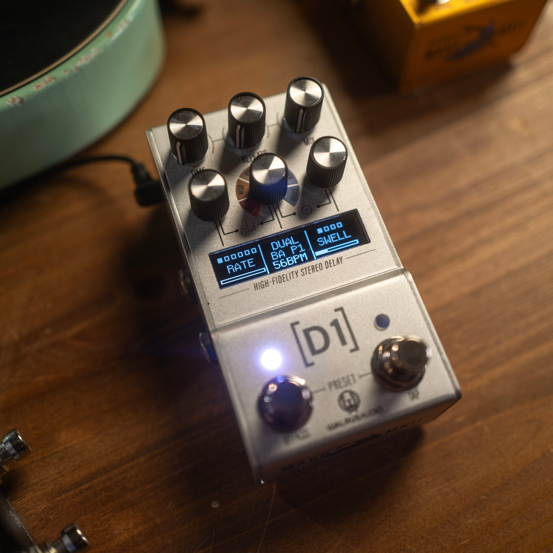A silver stereo delay effect pedal with knobs and a blue display screen.