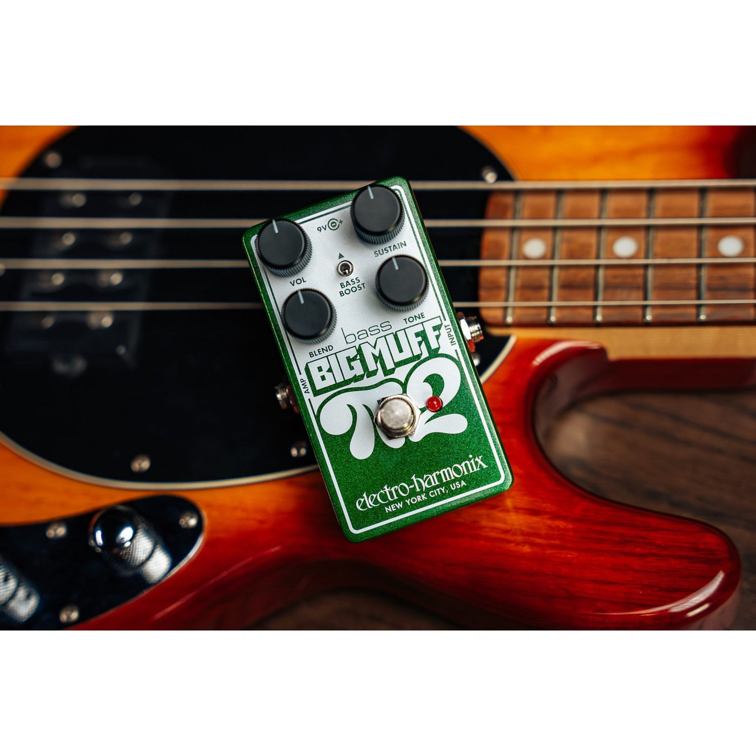 Green Bass Big Muff effect pedal lying on an electric guitar.