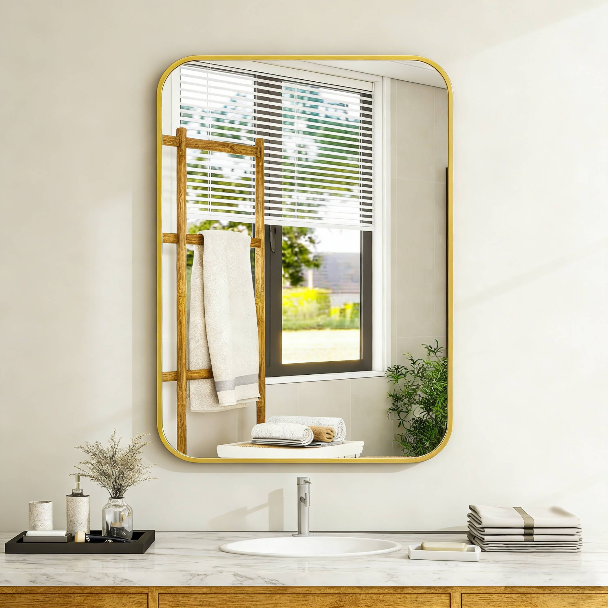 Ein Spiegel mit goldenem Rahmen hängt über einem Waschbecken mit Holzakzenten.