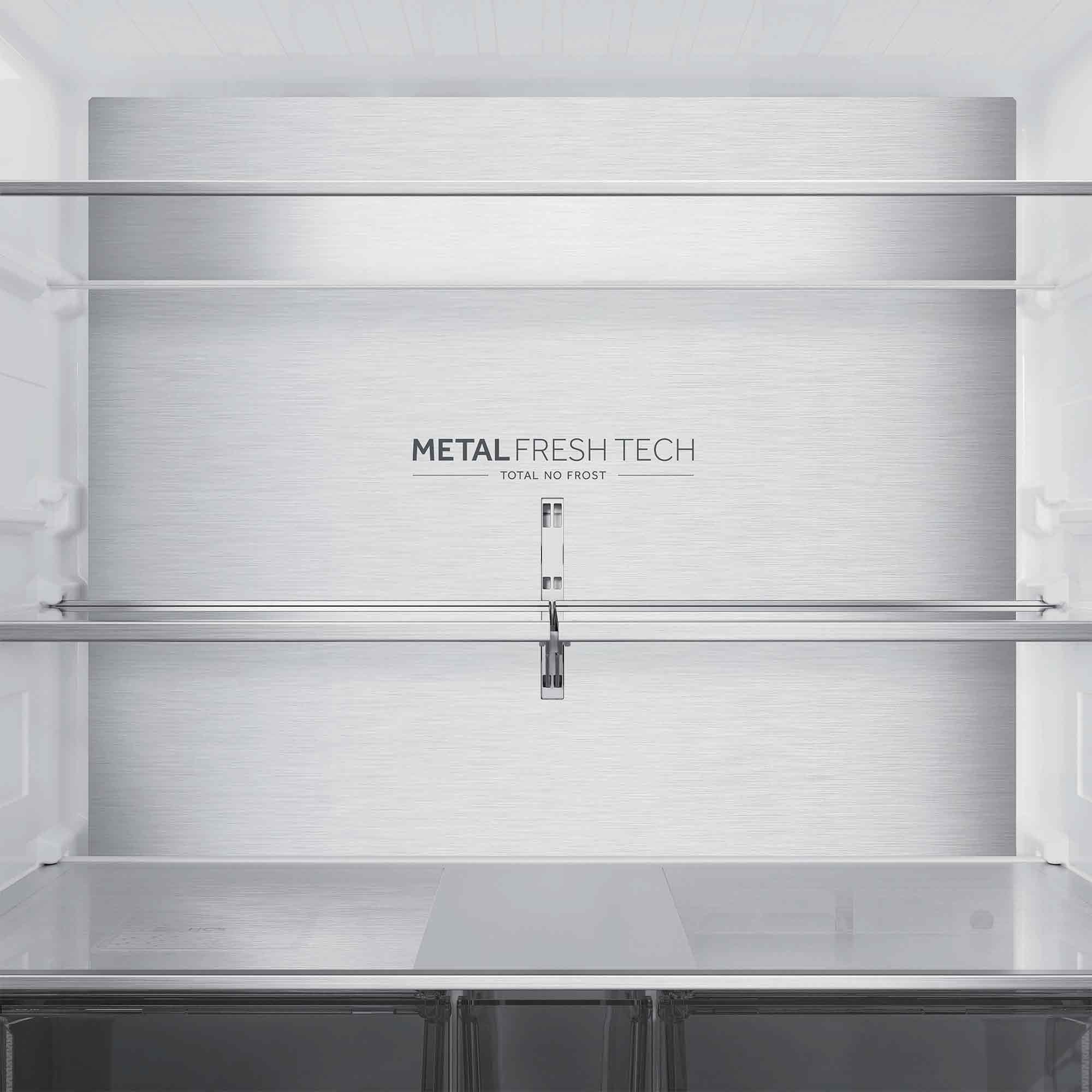 Interior de un refrigerador vacío con superficies metálicas y estantes.