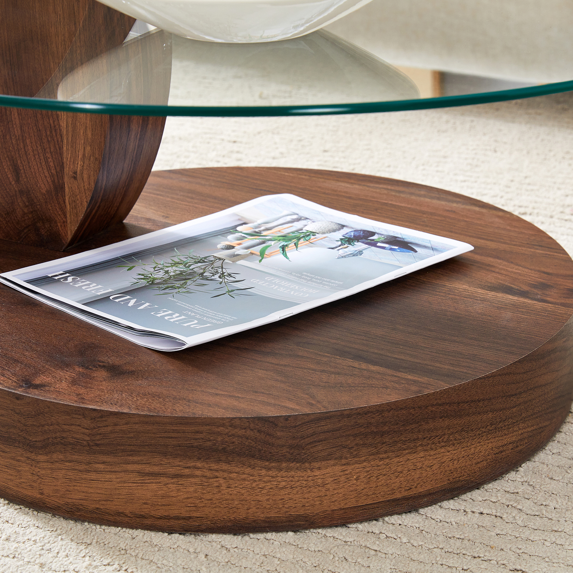 Ein Magazin liegt auf einem runden Holztisch mit Glasplatte. Naturmotive sind abgebildet.