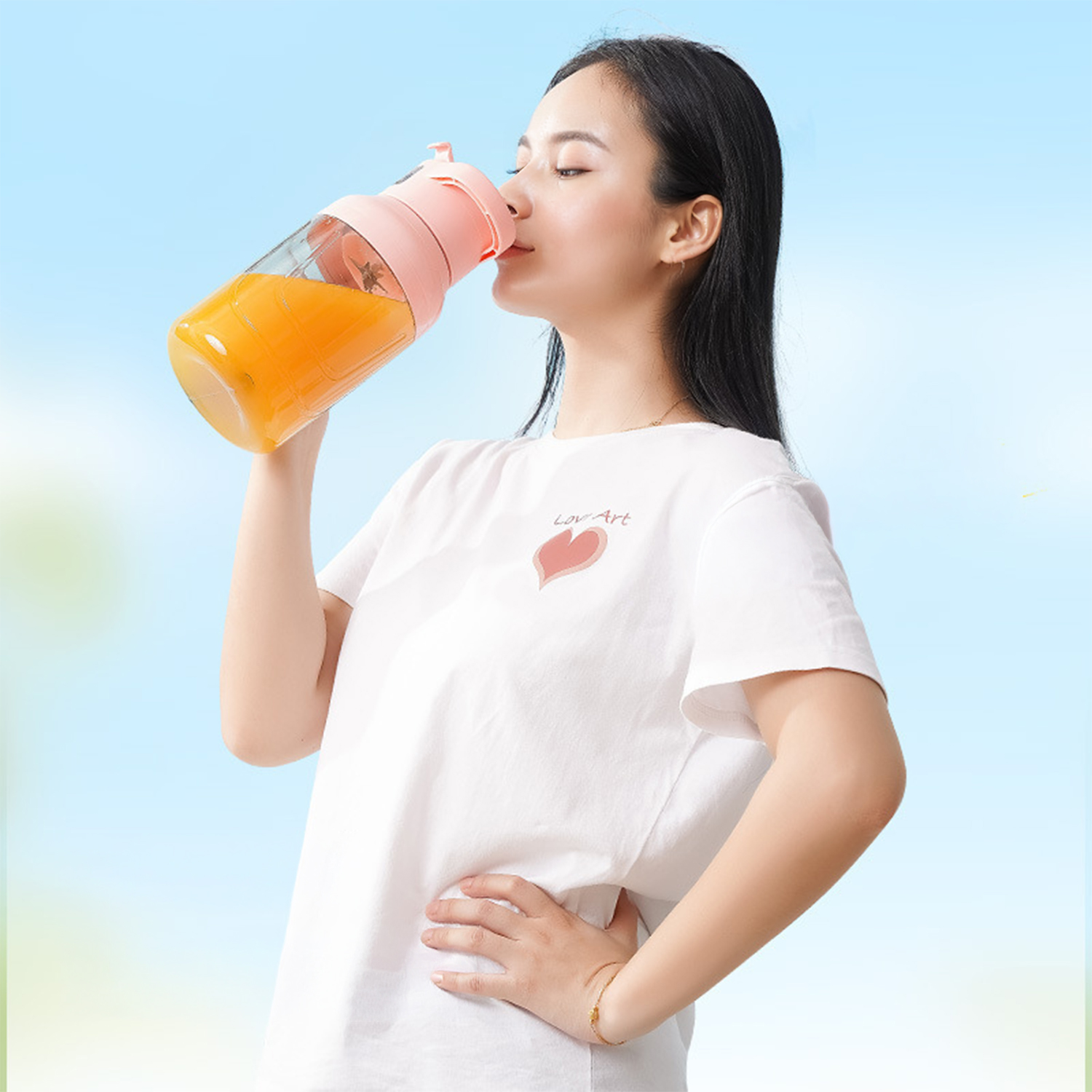 Una mujer bebe zumos de naranja de una botella rosa y transparente.