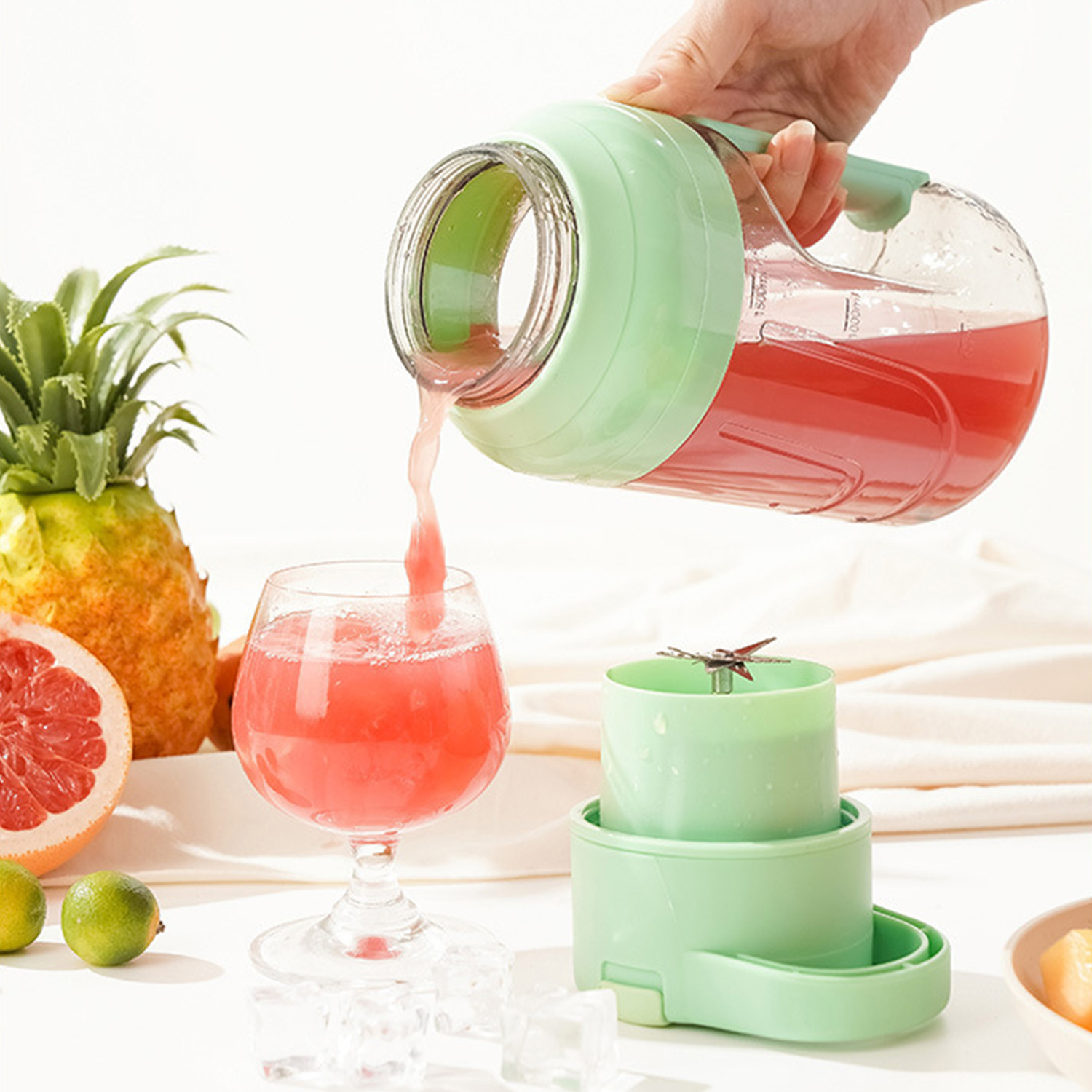 Una jarra de jugo rojo se vierte en un vaso. Hay frutas al lado.