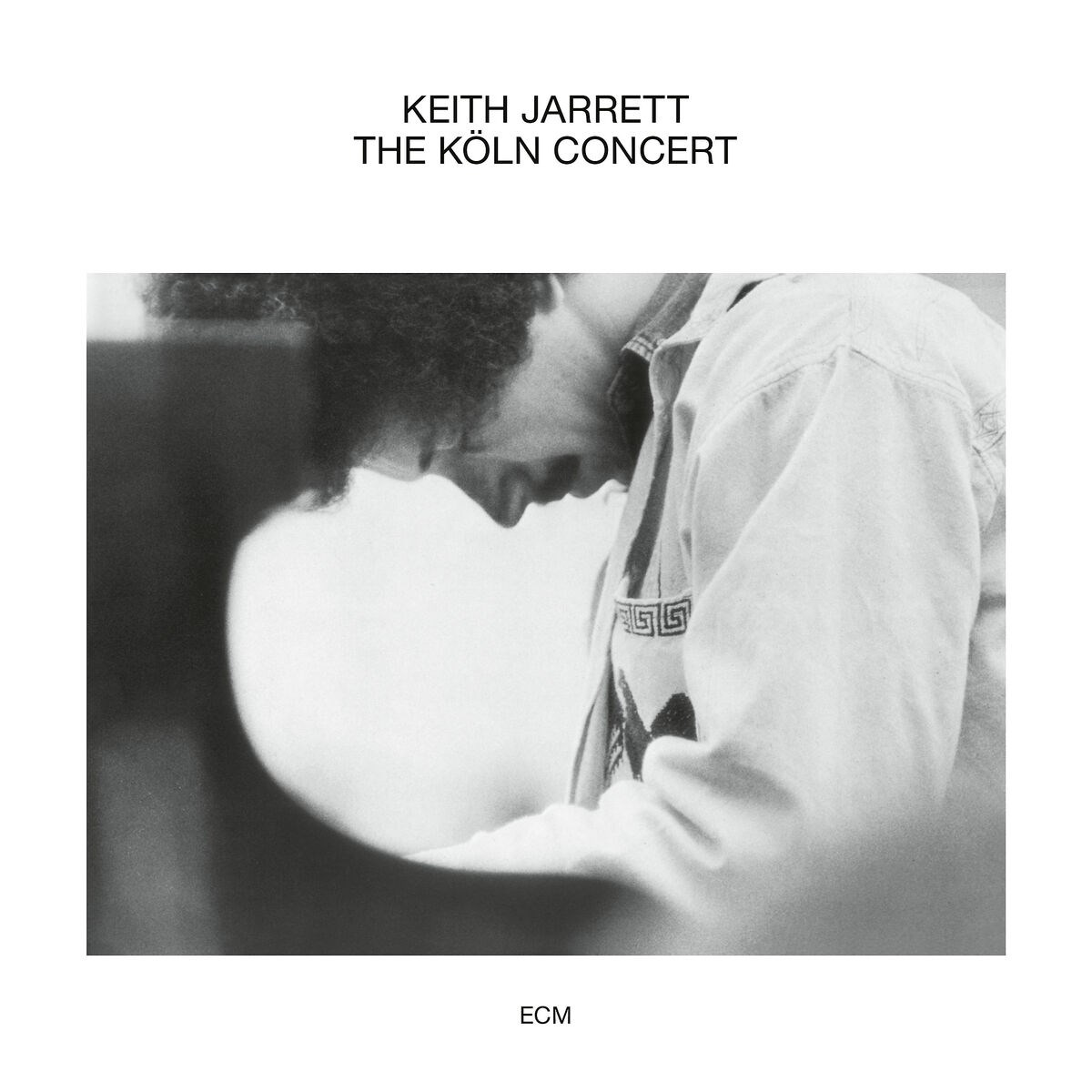 Foto in bianco e nero di un uomo chino su un pianoforte. Testo in alto: KEITH JARRETT THE KÖLN CONCERT.