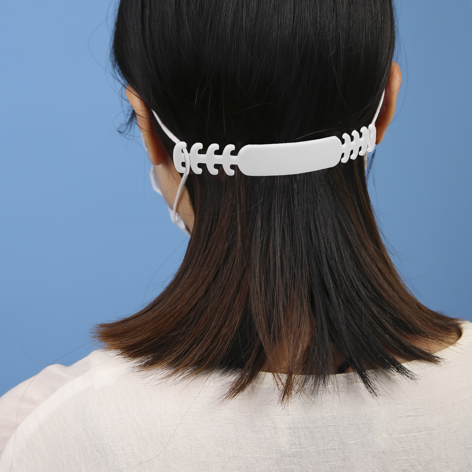 Vista trasera de una persona con mascarilla y extensor de correa blanco.