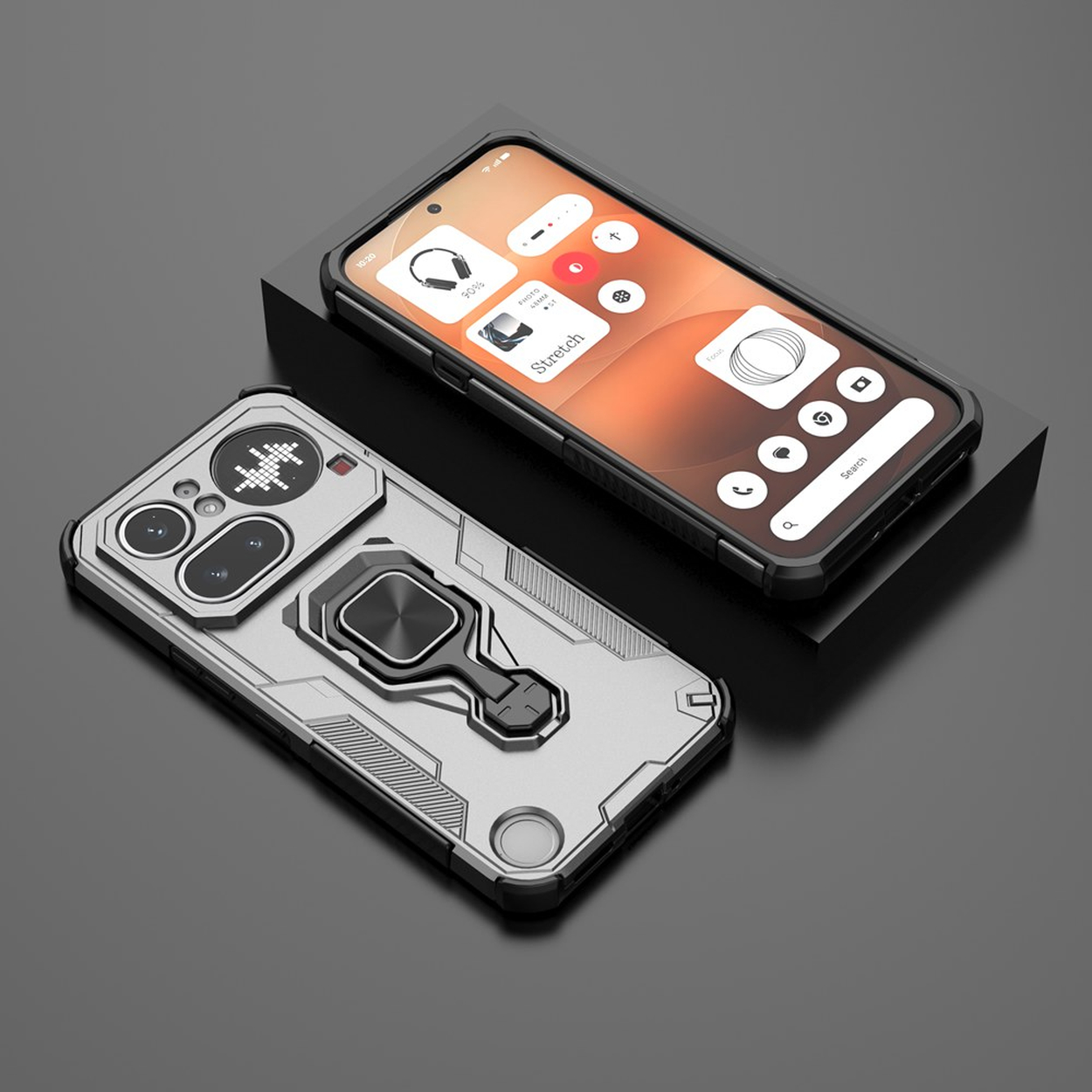 Un téléphone argenté avec support anneau repose à côté d'un smartphone noir sur un piédestal.