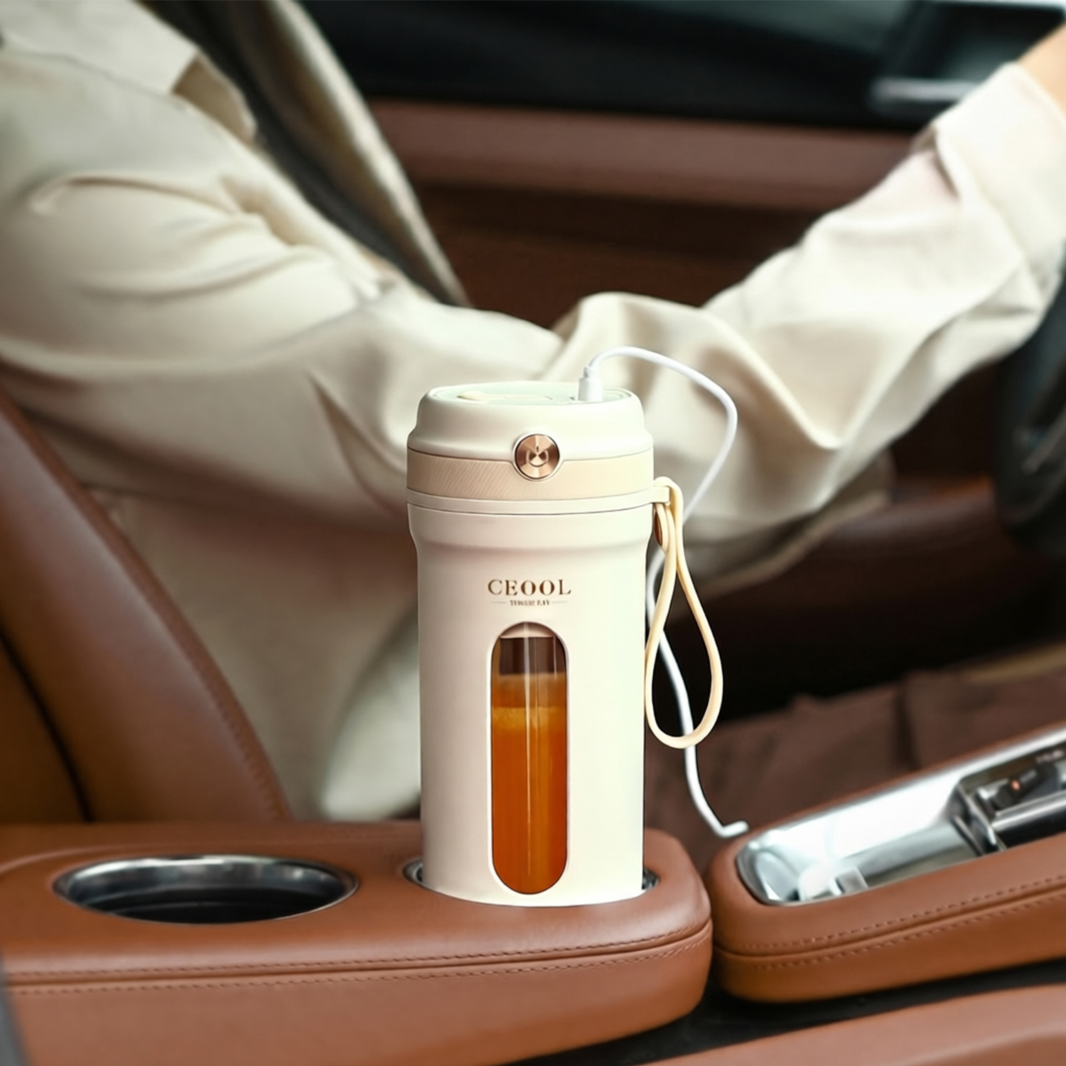 Una licuadora portátil en un coche, con jugo de naranja dentro, enchufada.