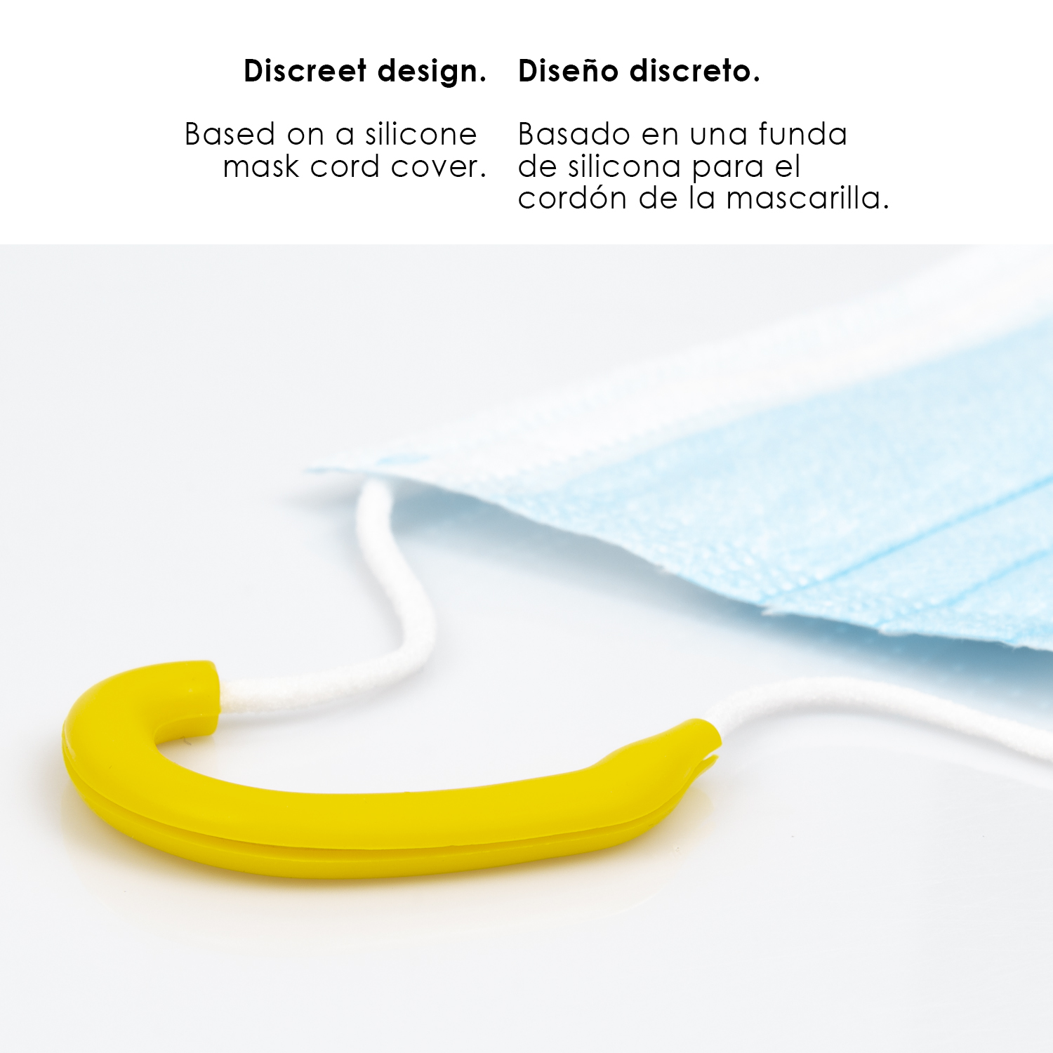 Una funda amarilla de silicona para cordón de mascarilla descansa sobre una mascarilla azul.