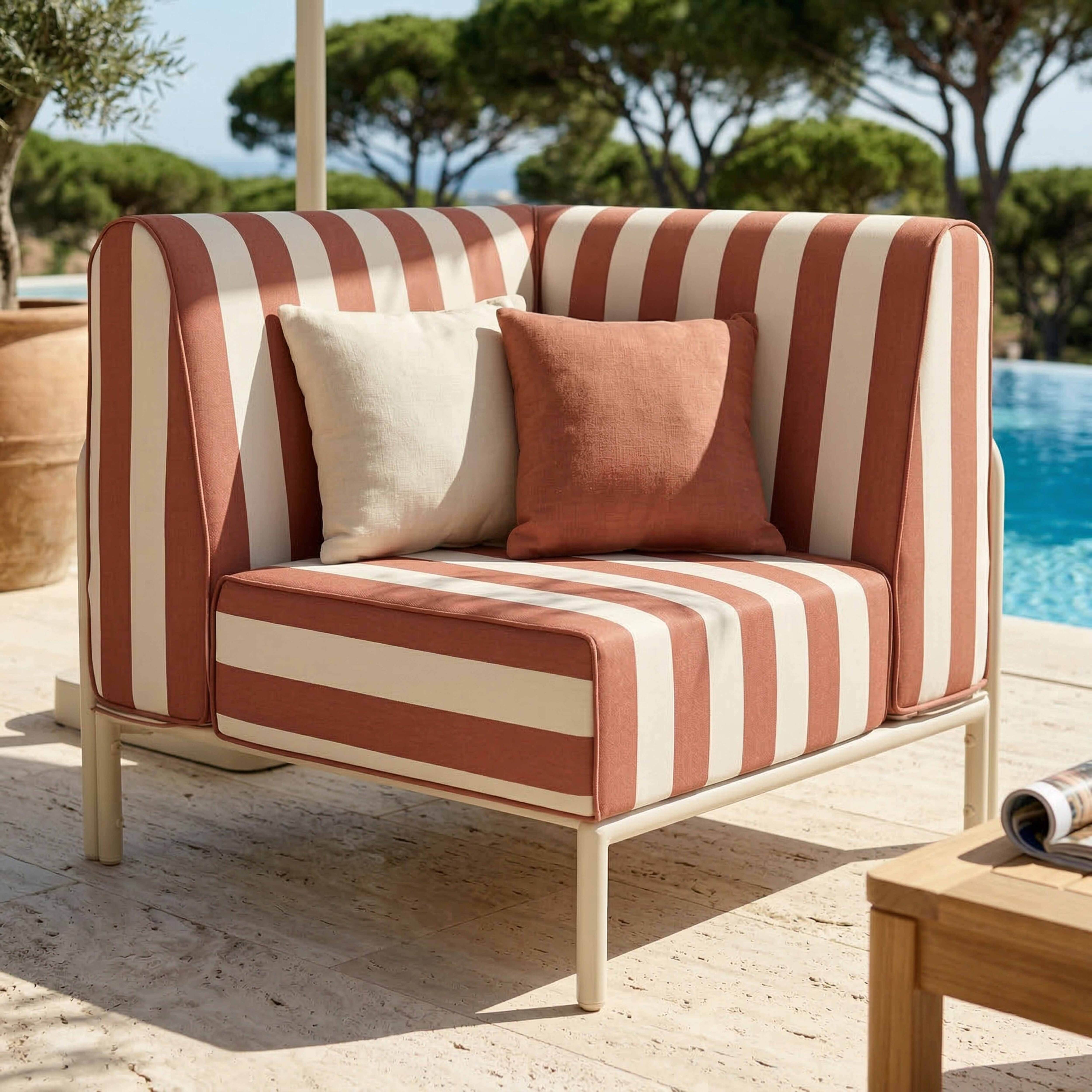 Gestuftes Sofa mit rot-weißen Streifen und Kissen neben einem Pool im Freien.