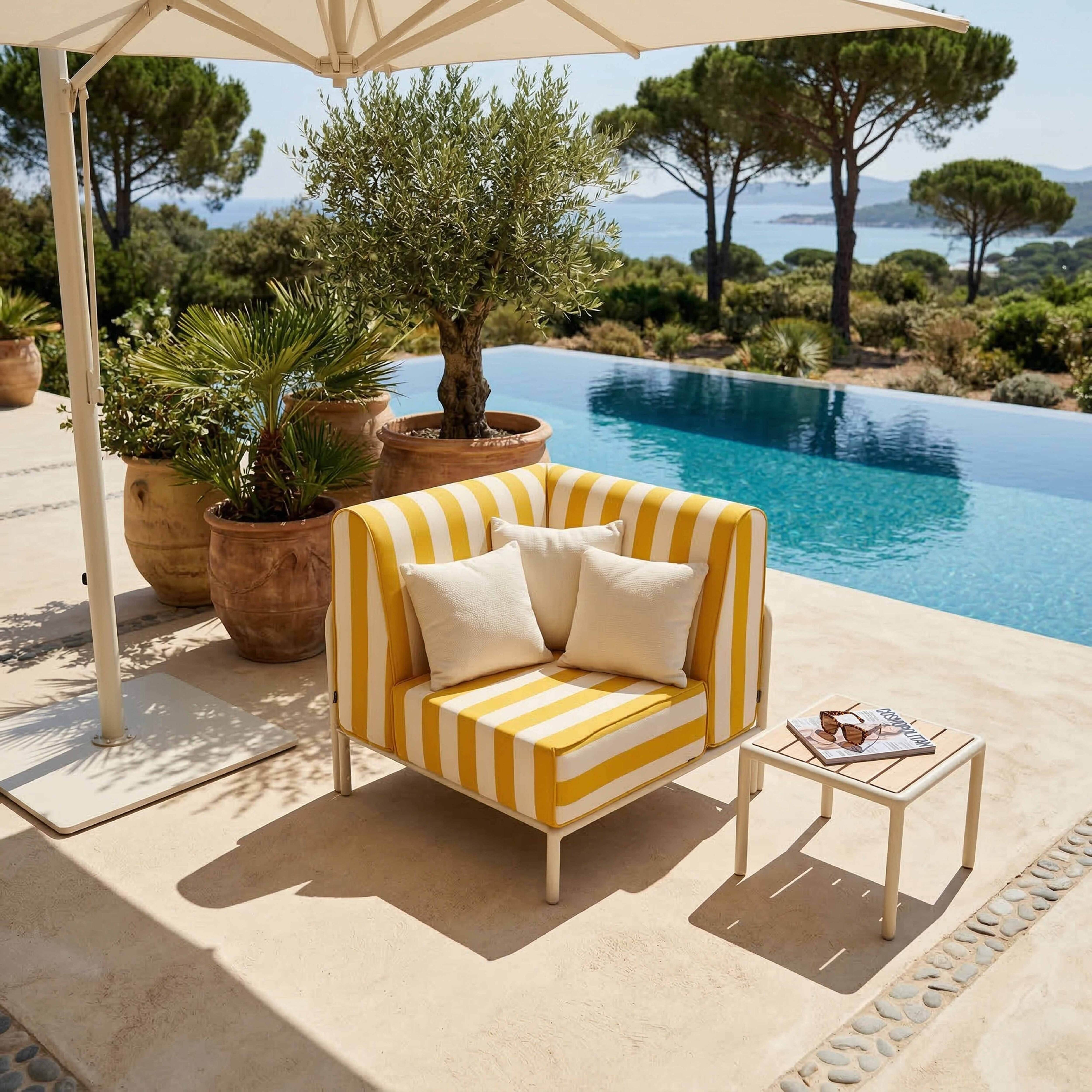 Ein gestreifter gelber Sessel am Pool mit Blick auf das Meer.