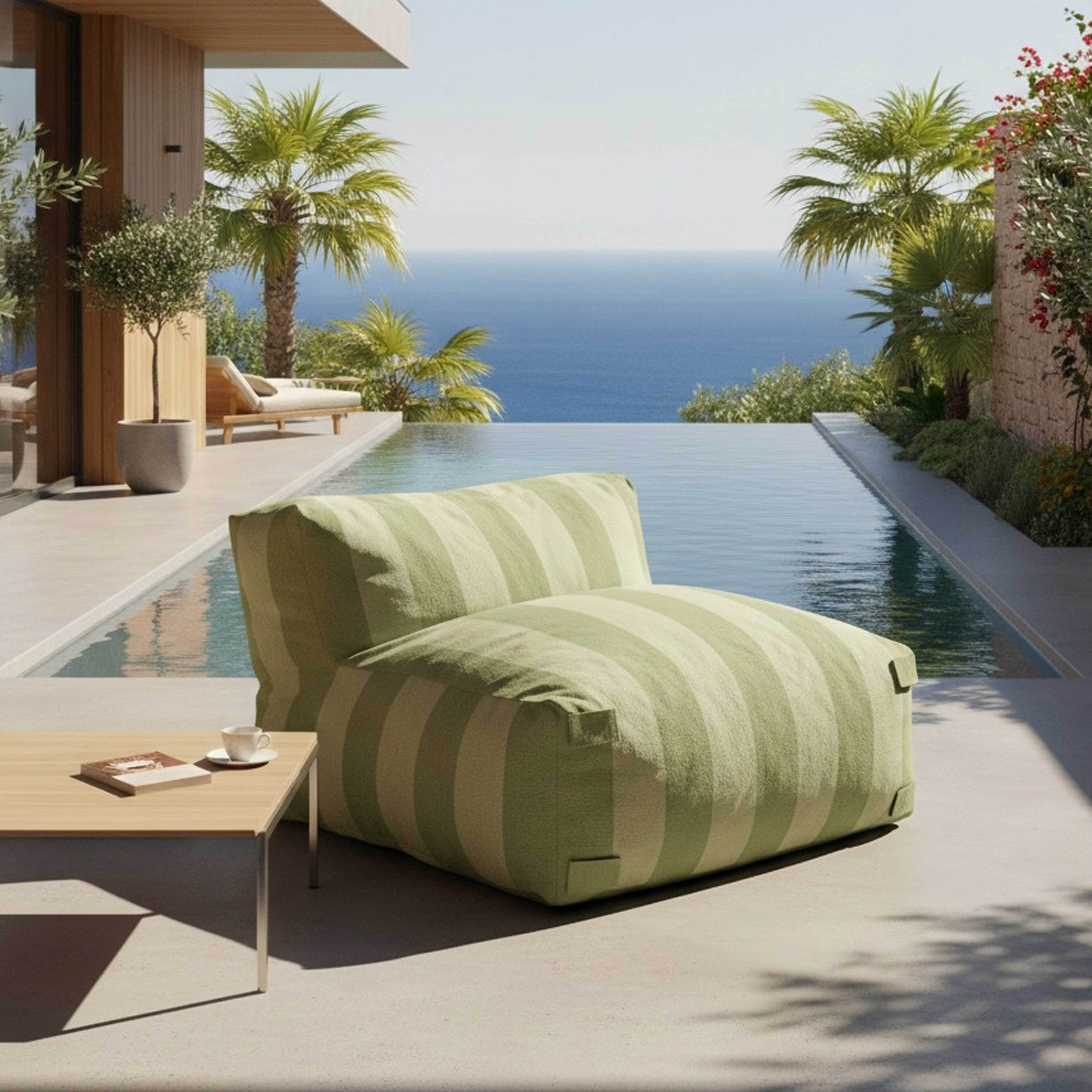 Ein gestreifter Sitzsack steht an einem Infinity-Pool mit Blick auf das Meer.