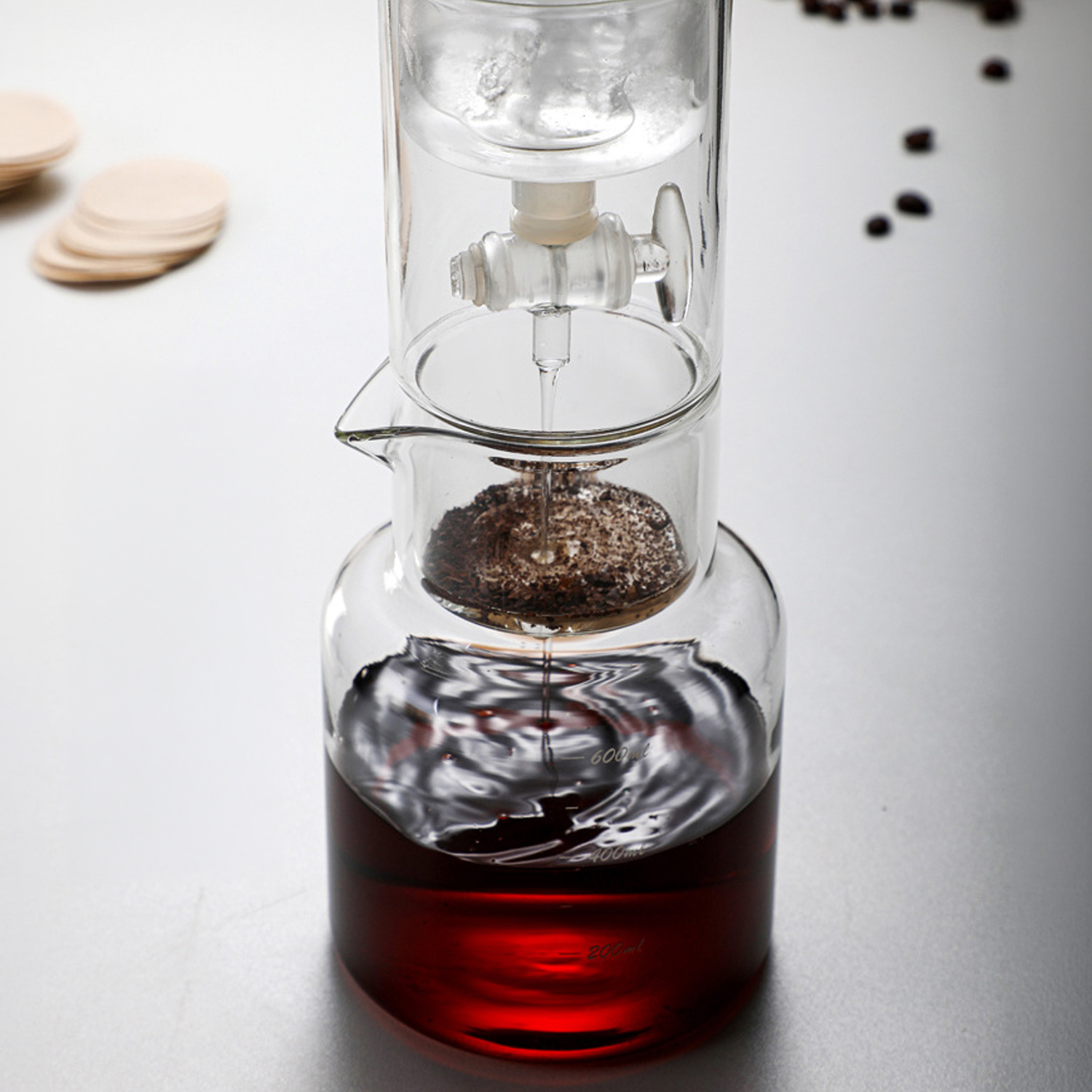 Cafetera de goteo de vidrio con gotas, café en la jarra inferior.