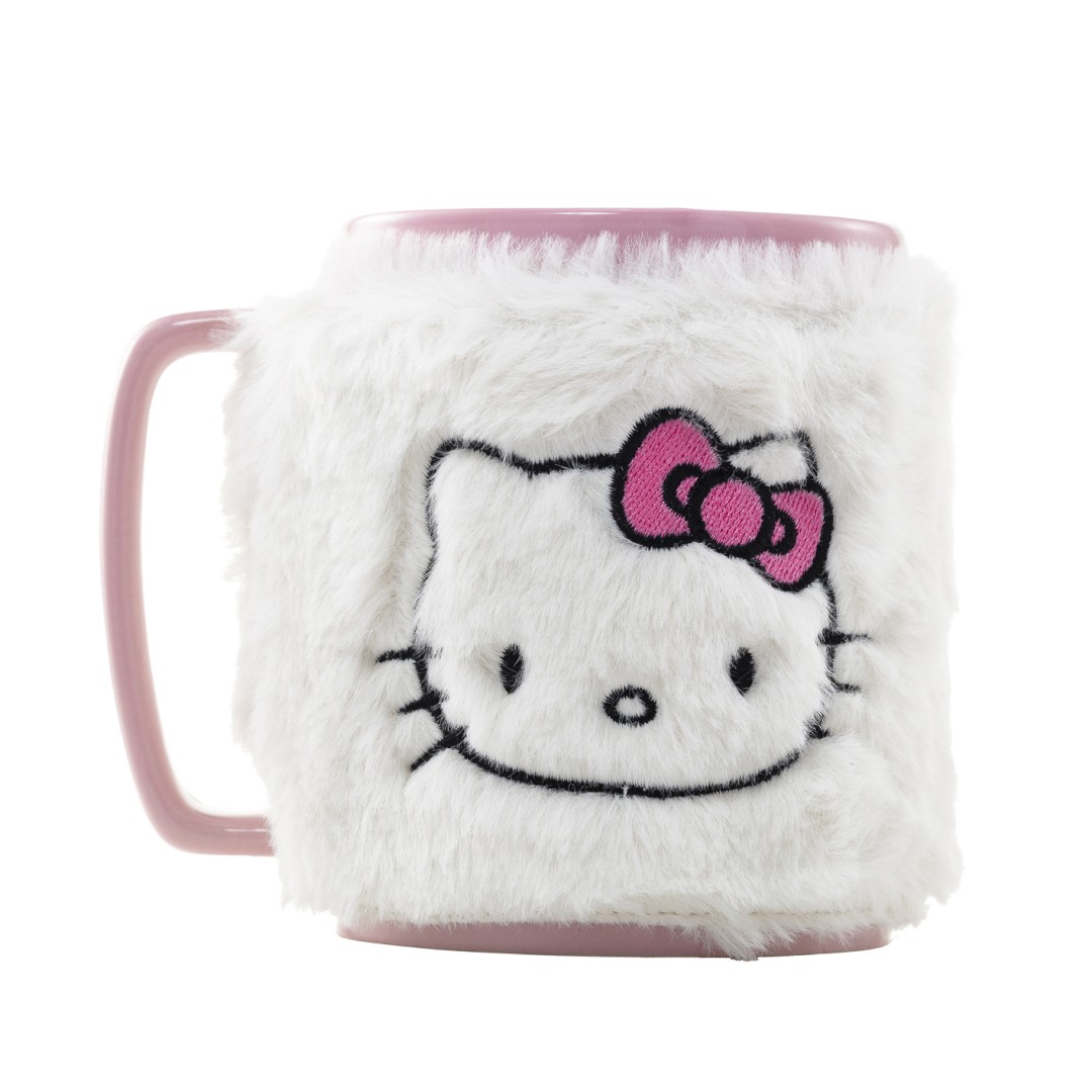 Una taza blanca y peluda con borde rosa muestra la cara de Hello Kitty y un lazo rosa.