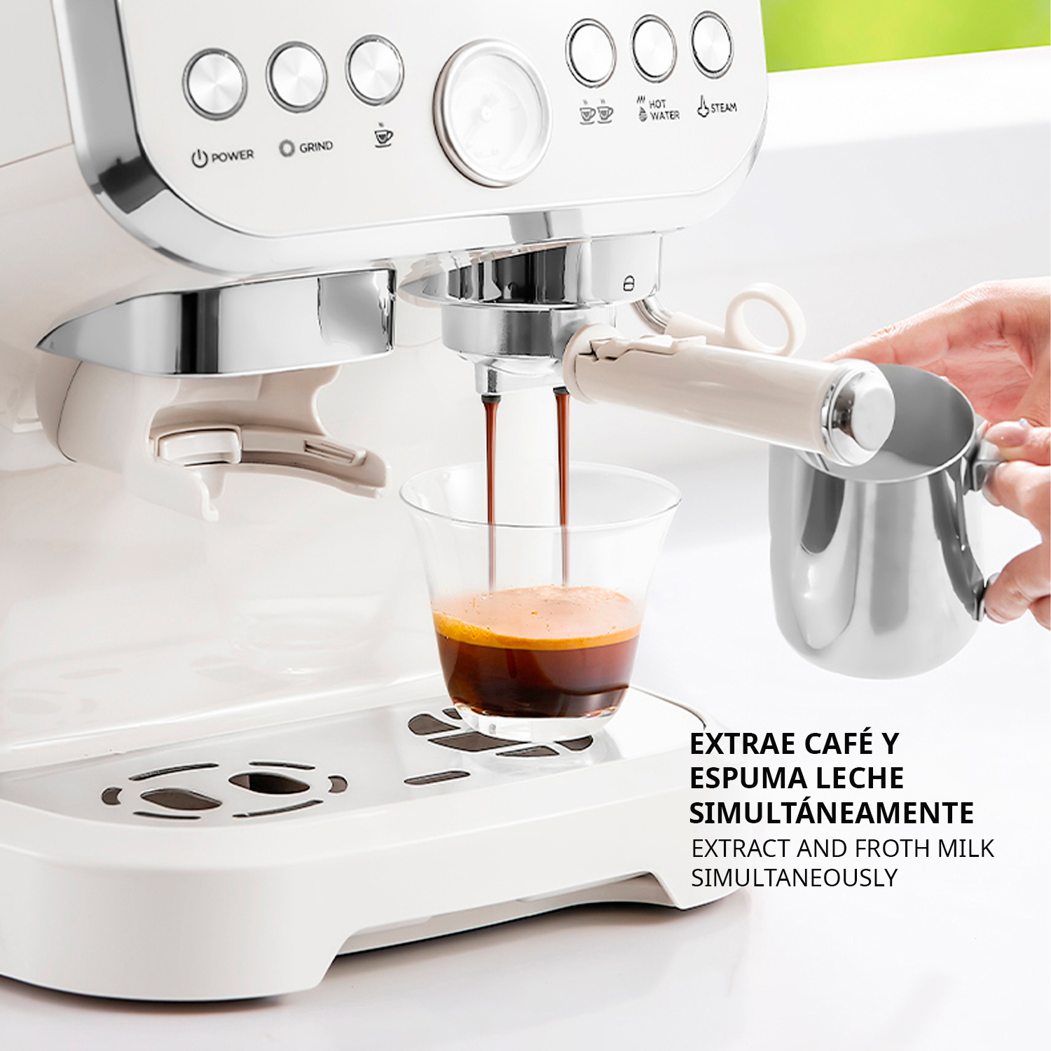 Eine weiße Kaffeemaschine brüht Espresso in ein Glas, ein Krug wird gehalten.