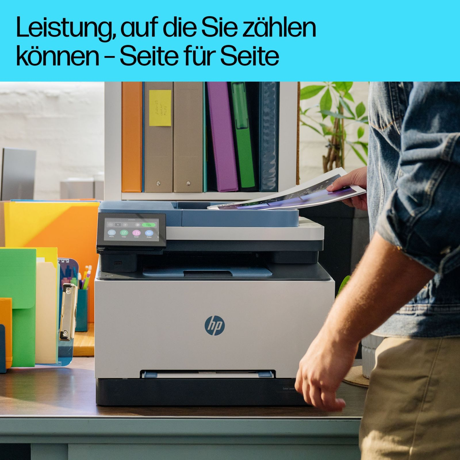 Mężczyzna wkłada kartkę do drukarki HP. Na półce stoją foldery.