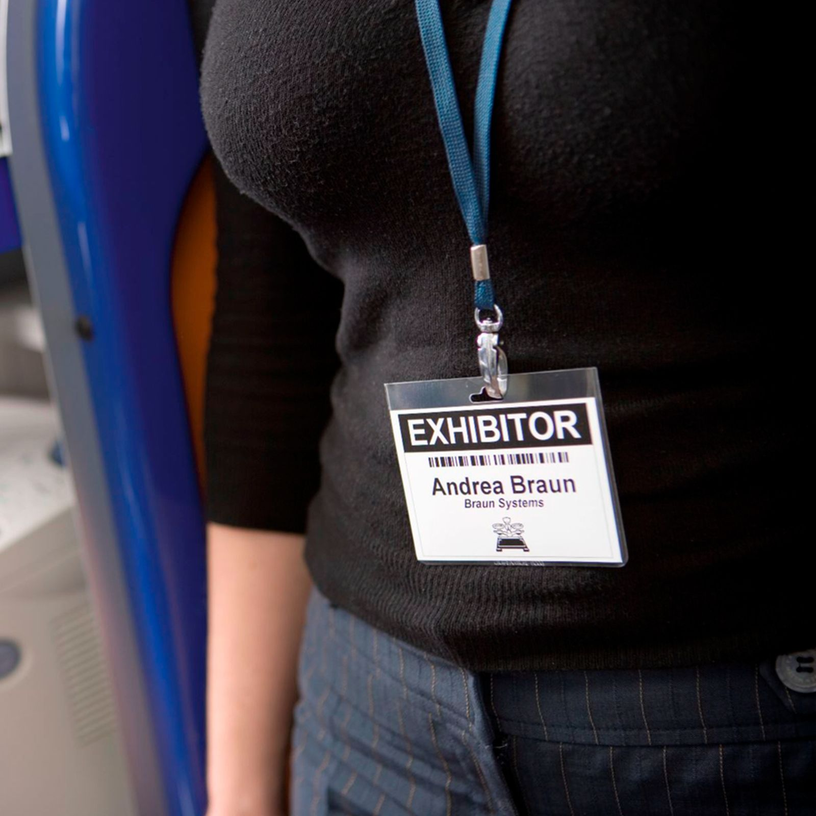 Persona con un badge espositore per Andrea Braun, Braun Systems. Maglia nera, laccetto blu.