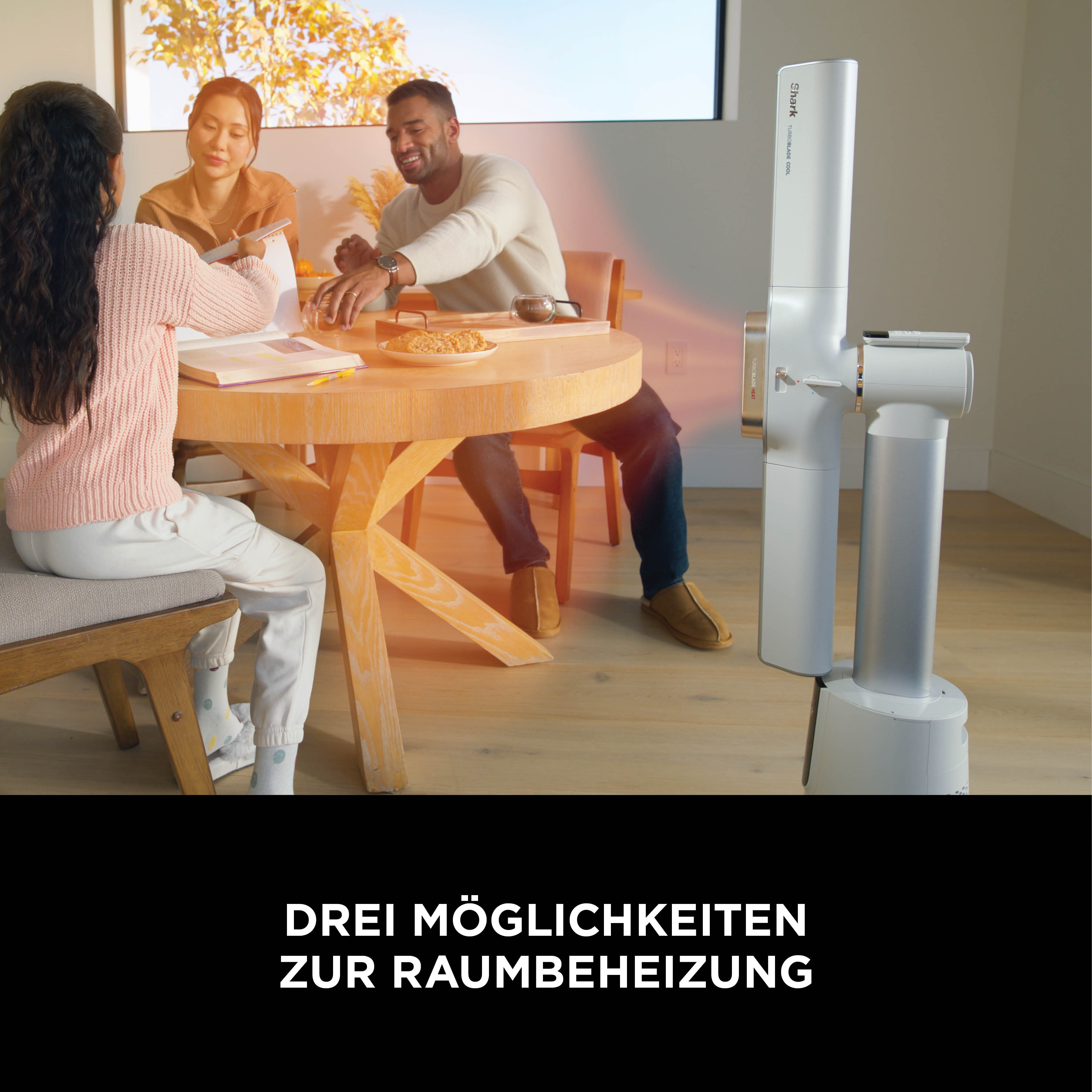Familie am Esstisch, daneben ein Shark Heizlüfter.