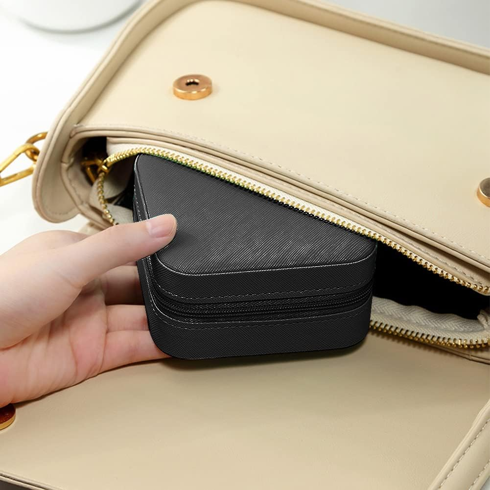 Eine Hand legt eine schwarze Reißverschlusstasche in eine beige Handtasche.