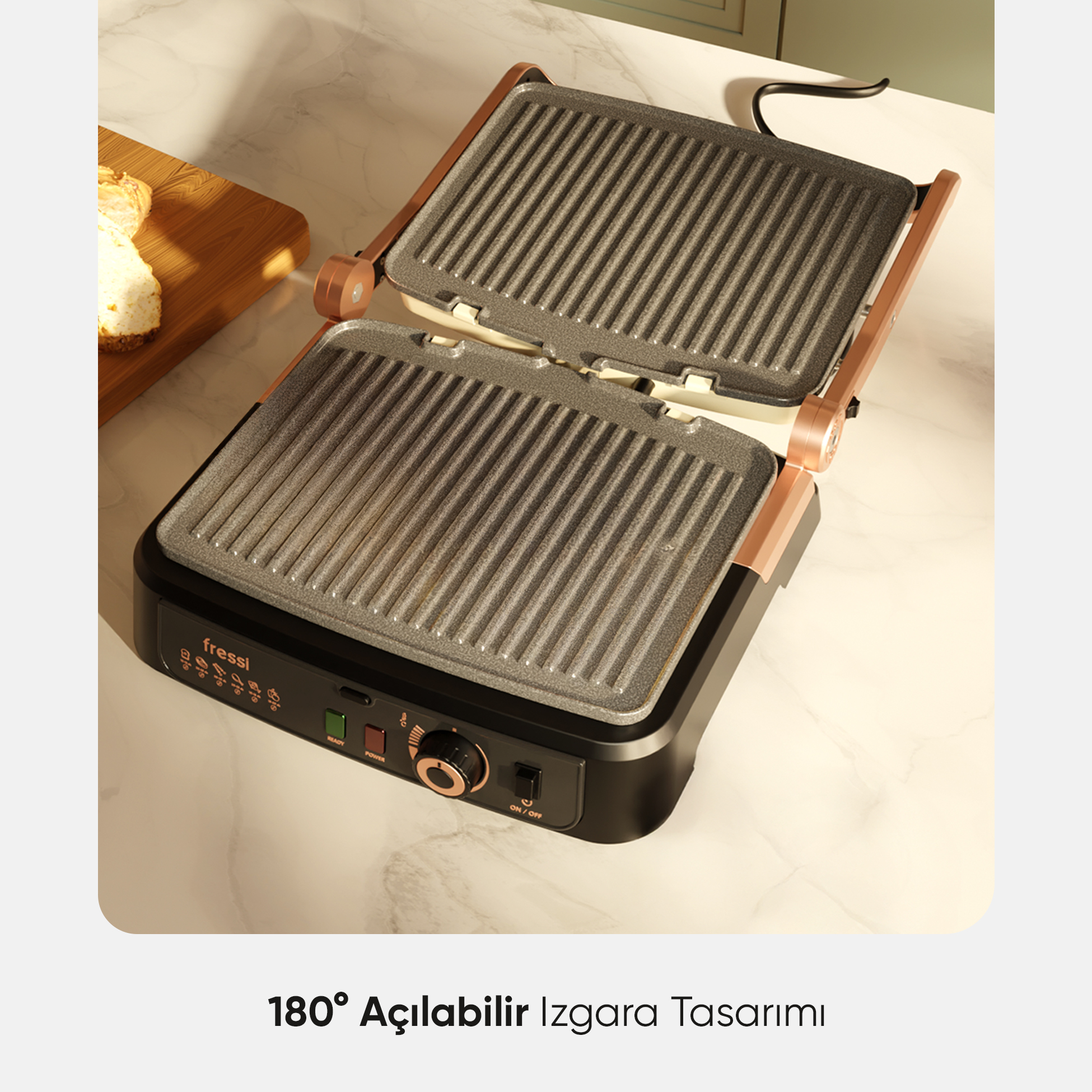 Bakır detaylı açık ızgara ve arkada tahta üzerinde ekmek dilimleri.