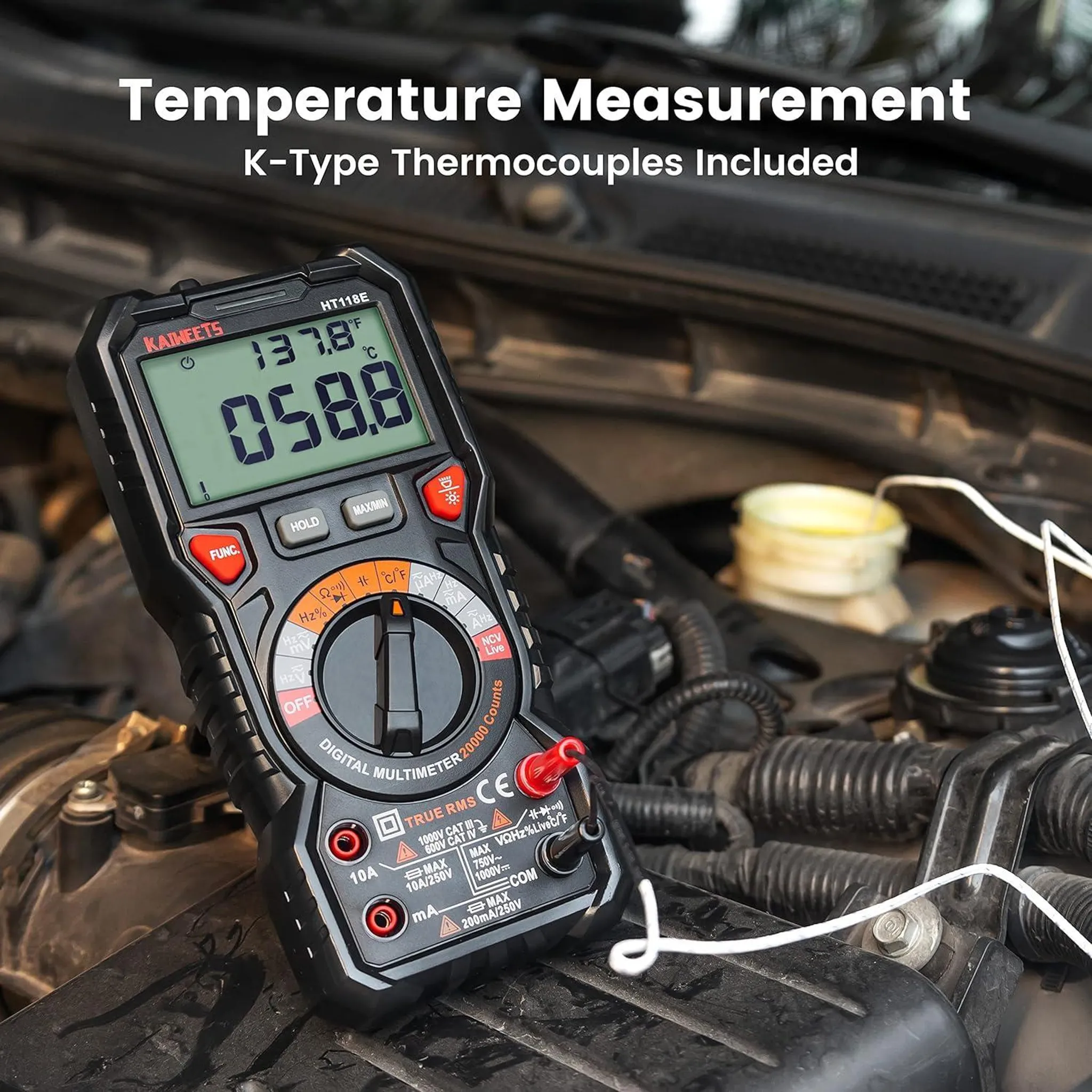 Ein schwarzes Multimeter mit Thermoelementen liegt auf einem Automotor.