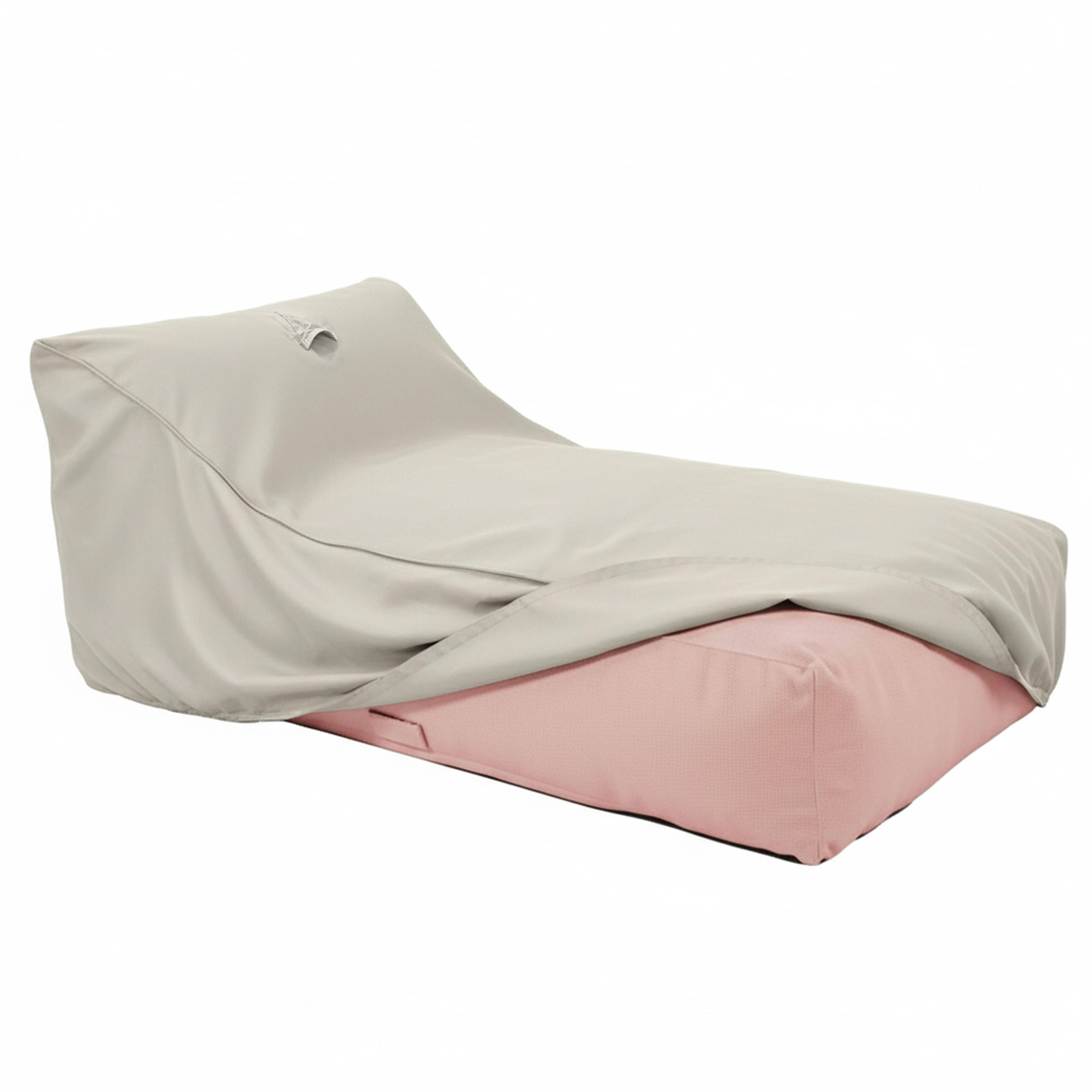Ein hellgrauer Überwurf bedeckt teilweise einen rosafarbenen Sitzsack.
