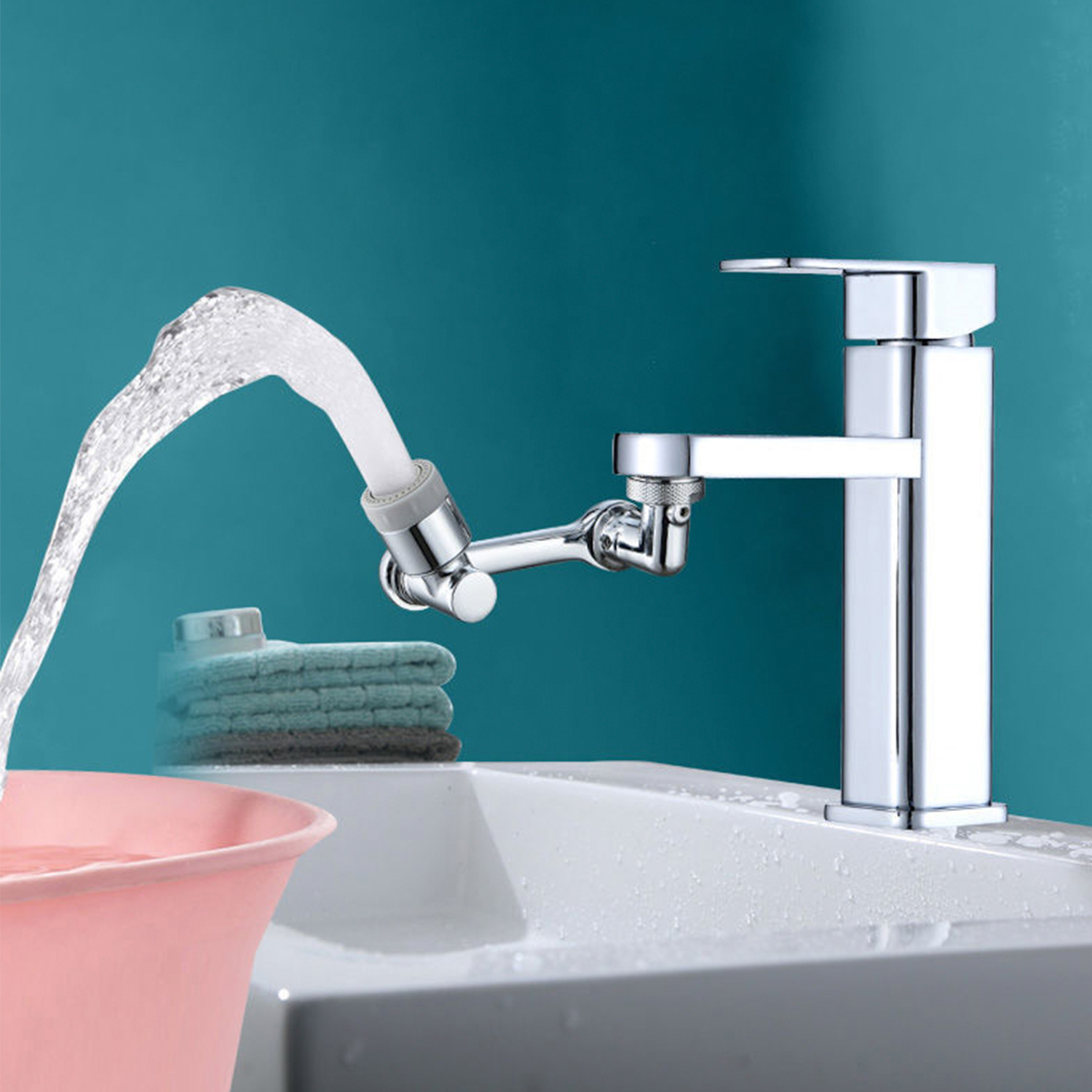 Un grifo cromado rocía agua en una cubeta rosa junto a una pila de toallas.