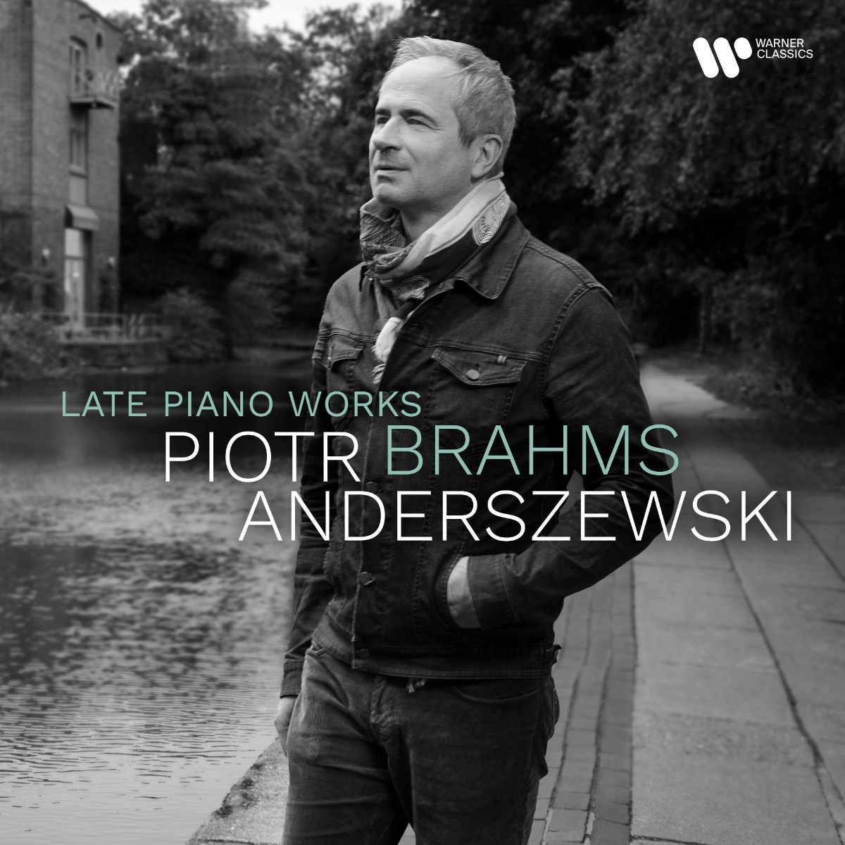 Un uomo vicino ad acqua e alberi. Logo Warner Classics in alto a destra.