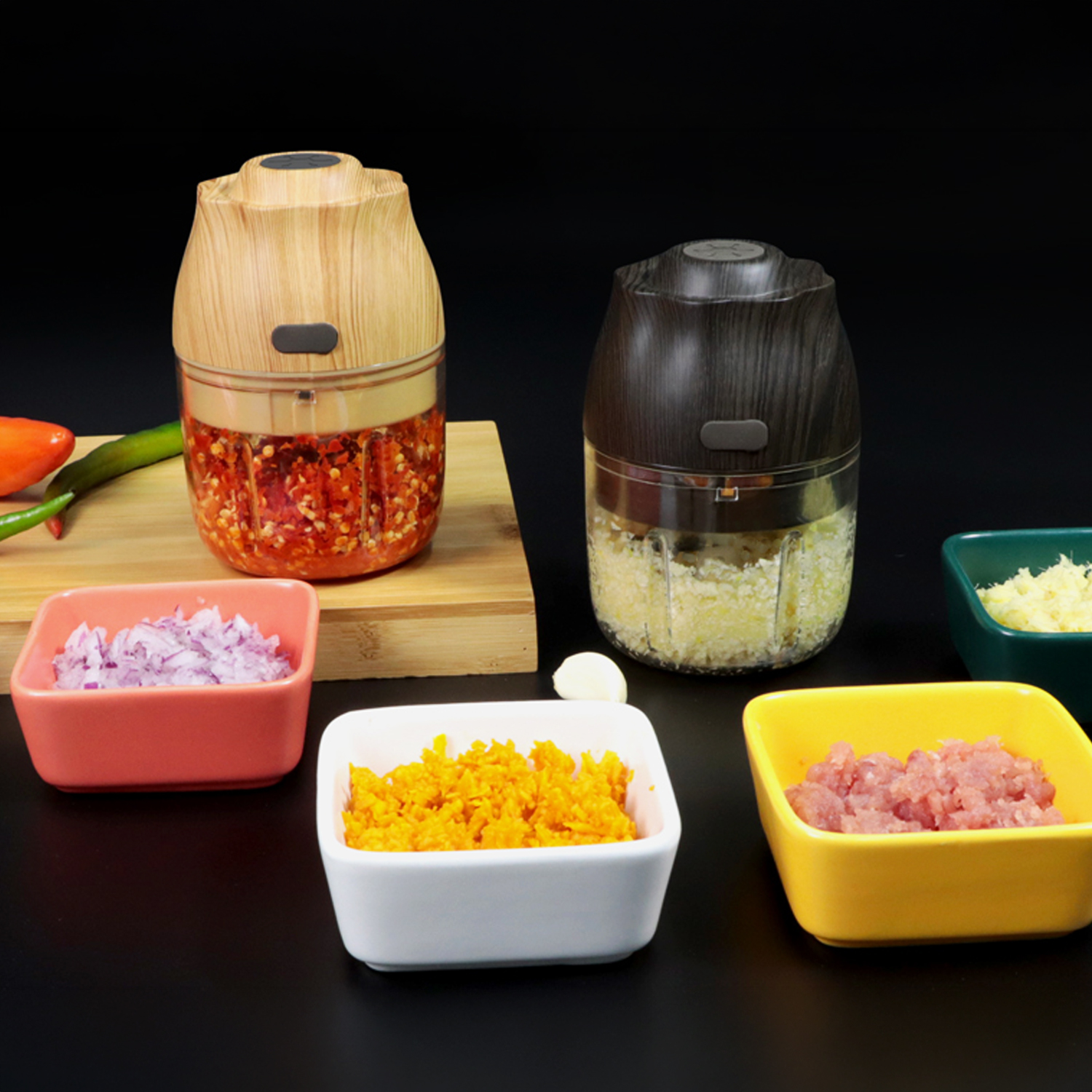 Picadoras de cocina con alimentos picados: chiles, cebollas, zanahorias, carne picada, ajo y queso.