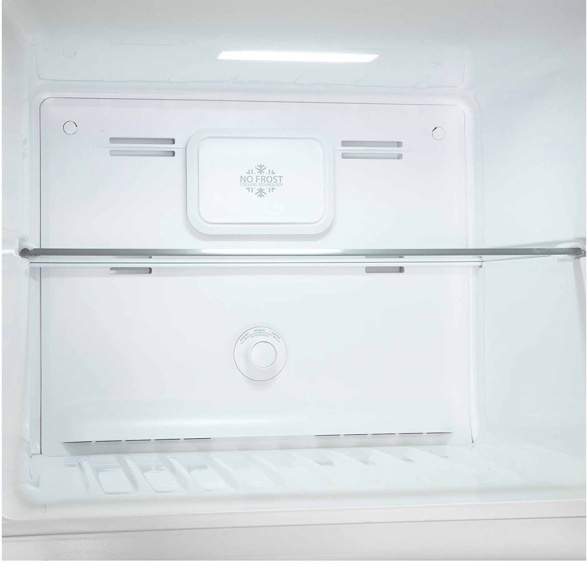 An empty refrigerator interior with a glass shelf and temperature dial.