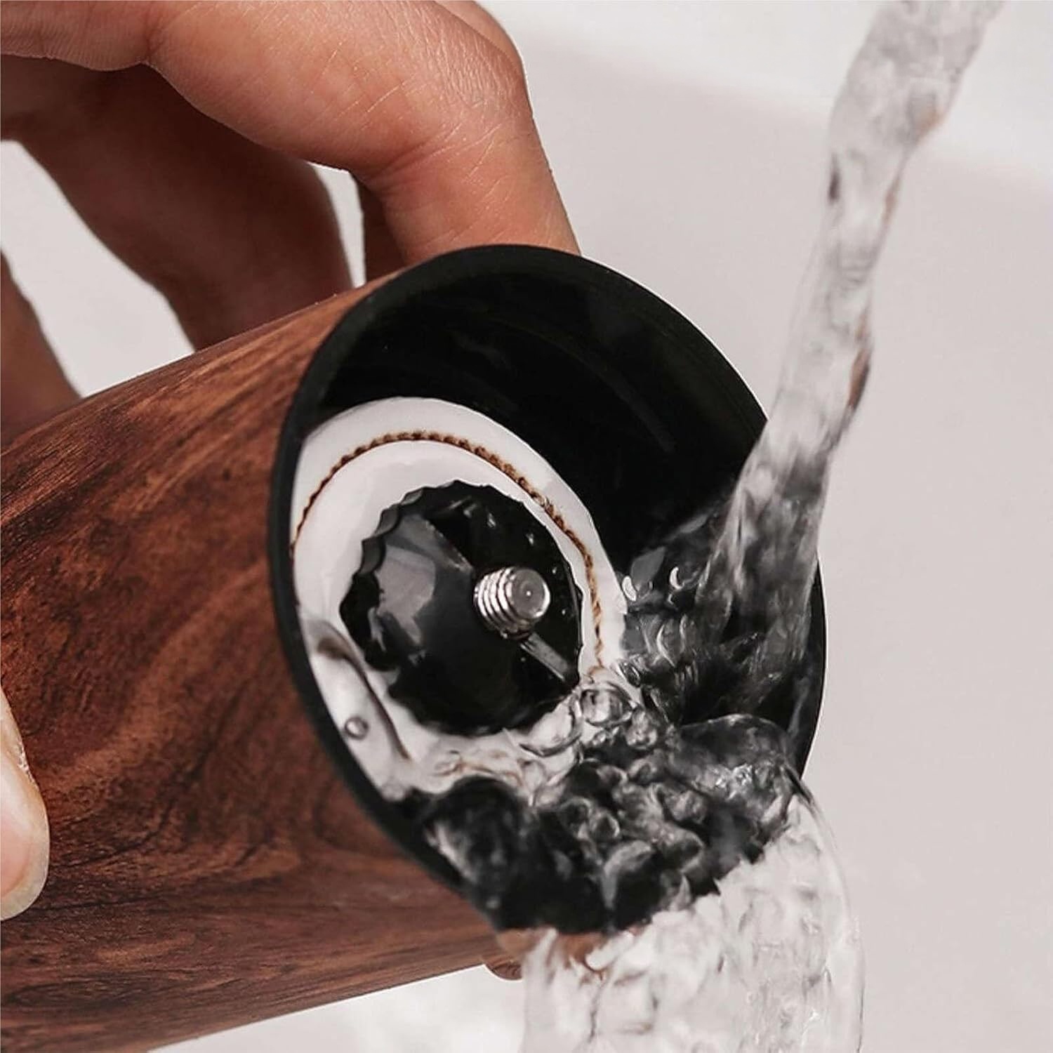 Se limpia la cabeza de un molino de madera bajo agua corriente.
