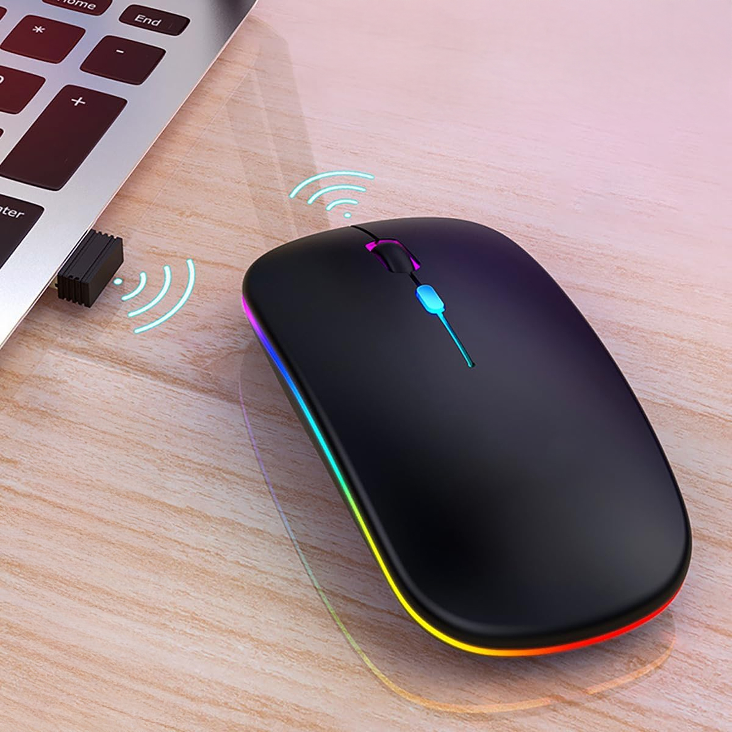 Ratón inalámbrico negro con iluminación LED colorida junto a un portátil y un dongle.