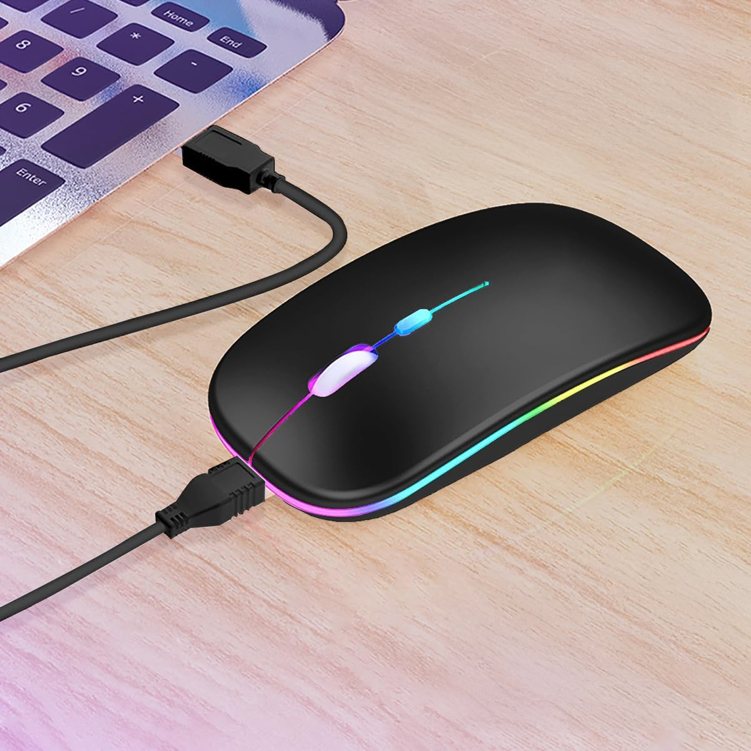Ratón negro con cable USB e iluminación RGB junto a un teclado.