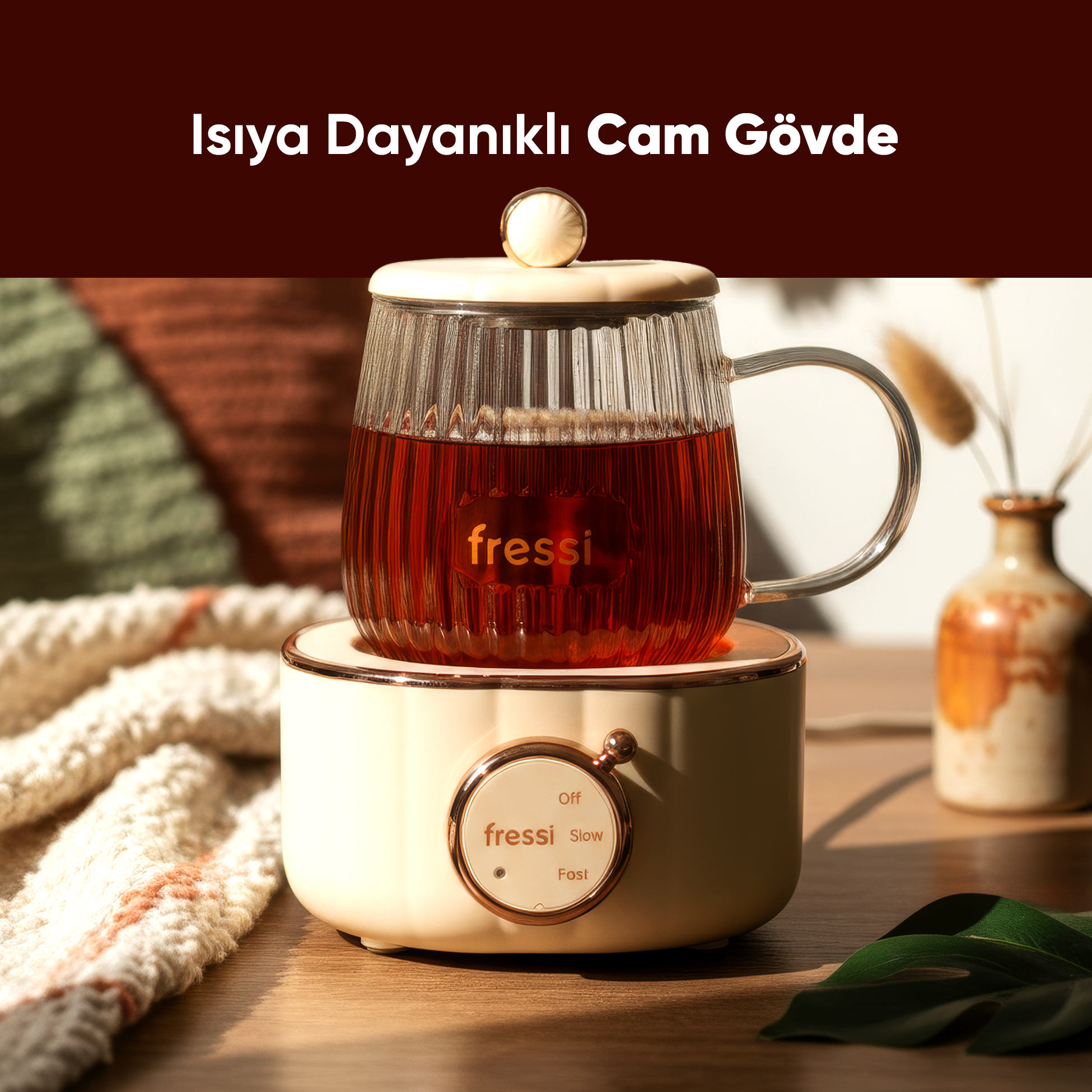 Çaylı cam kupa ısıtıcı taban üzerinde. Sol tarafta yumuşak battaniye.