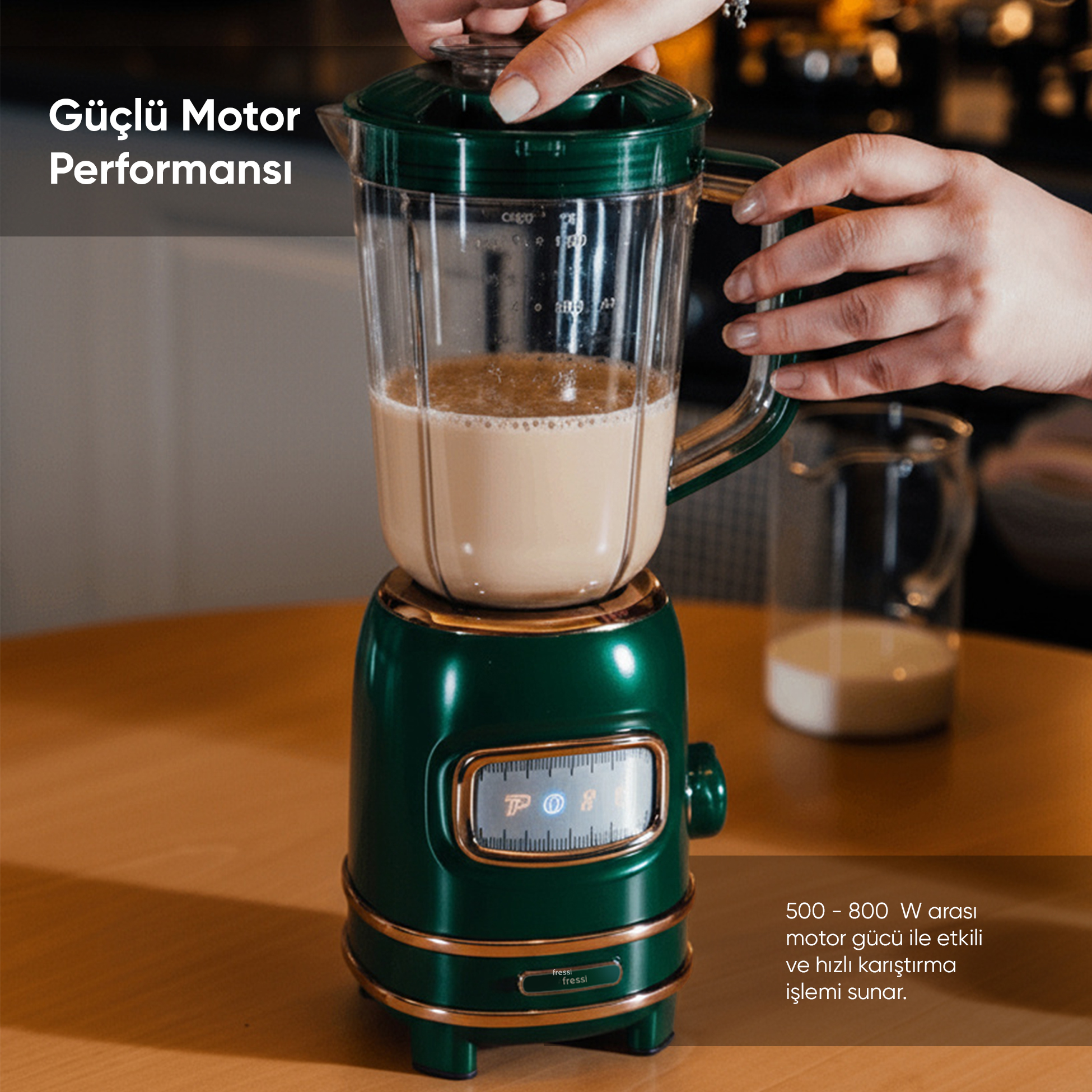 Altın rengi detaylara sahip yeşil blender, açık kahverengi sıvı ile kullanılıyor.