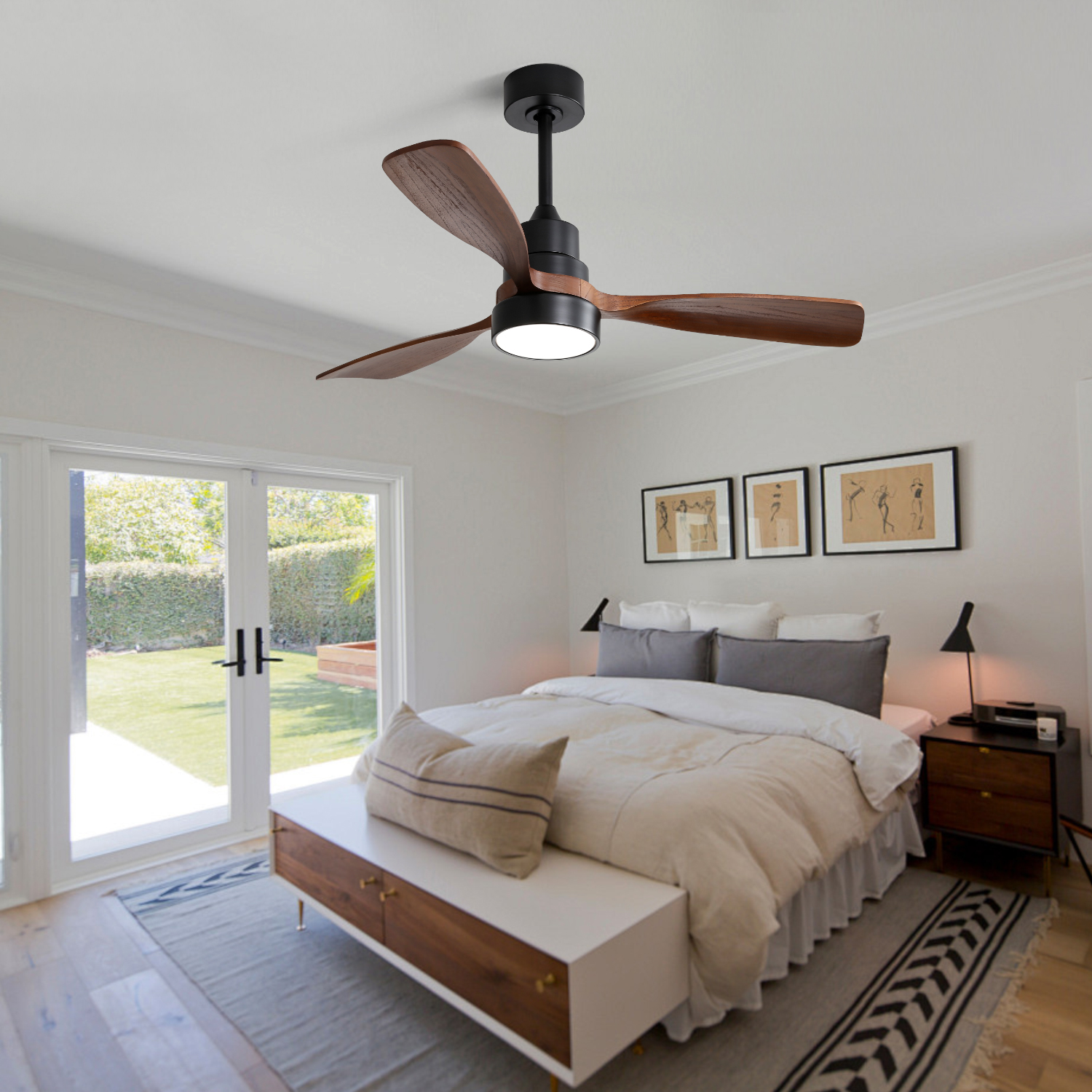 Ein Schlafzimmer mit Deckenventilator, Bett und Glastür nach draußen.