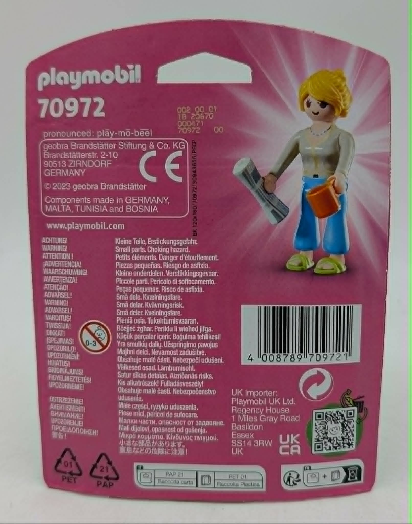 Playmobil Figur hält Zeitung und Becher, trägt Jeans und Sandalen.