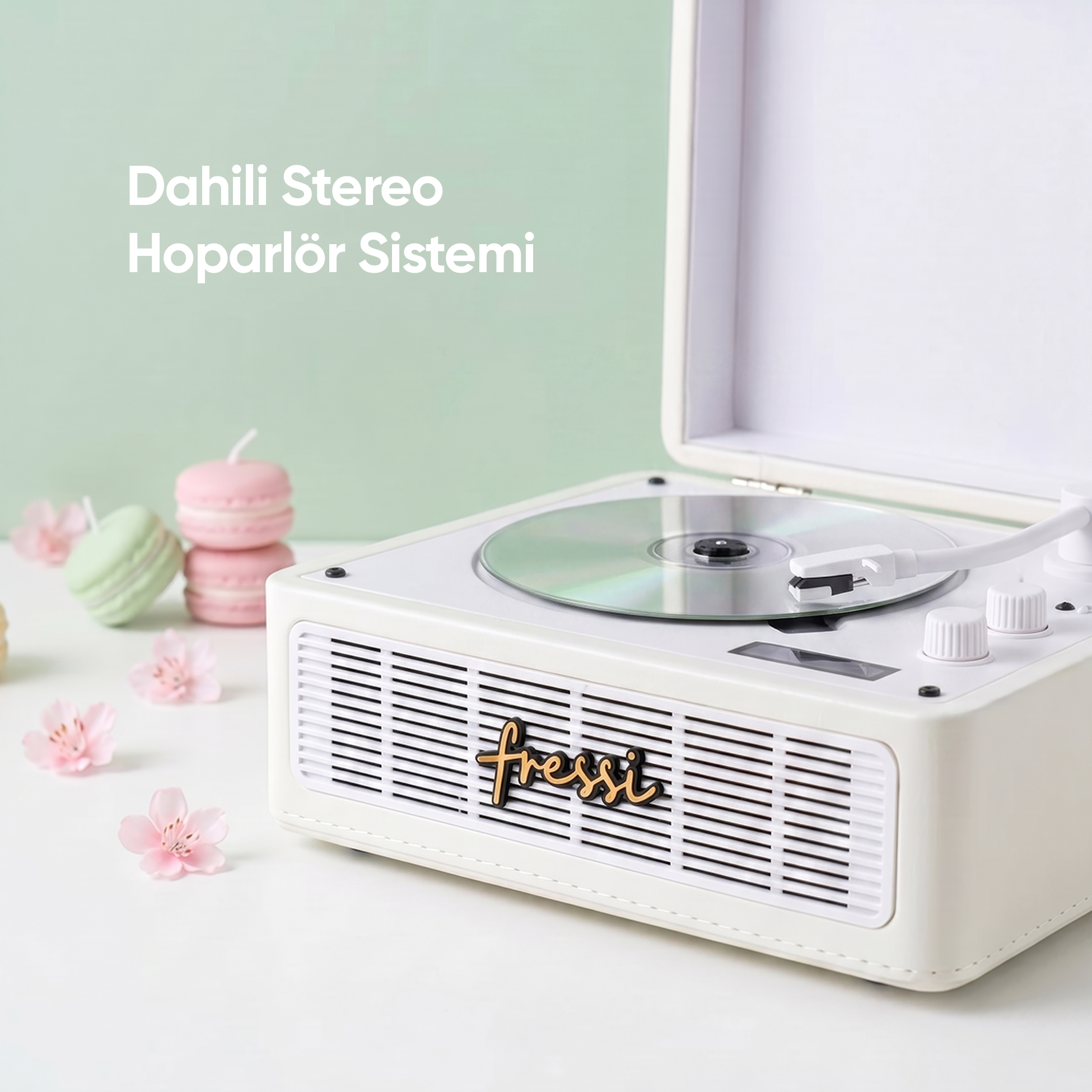 CD yuvalı beyaz pikap, makaron mumlar ve kiraz çiçekleri.