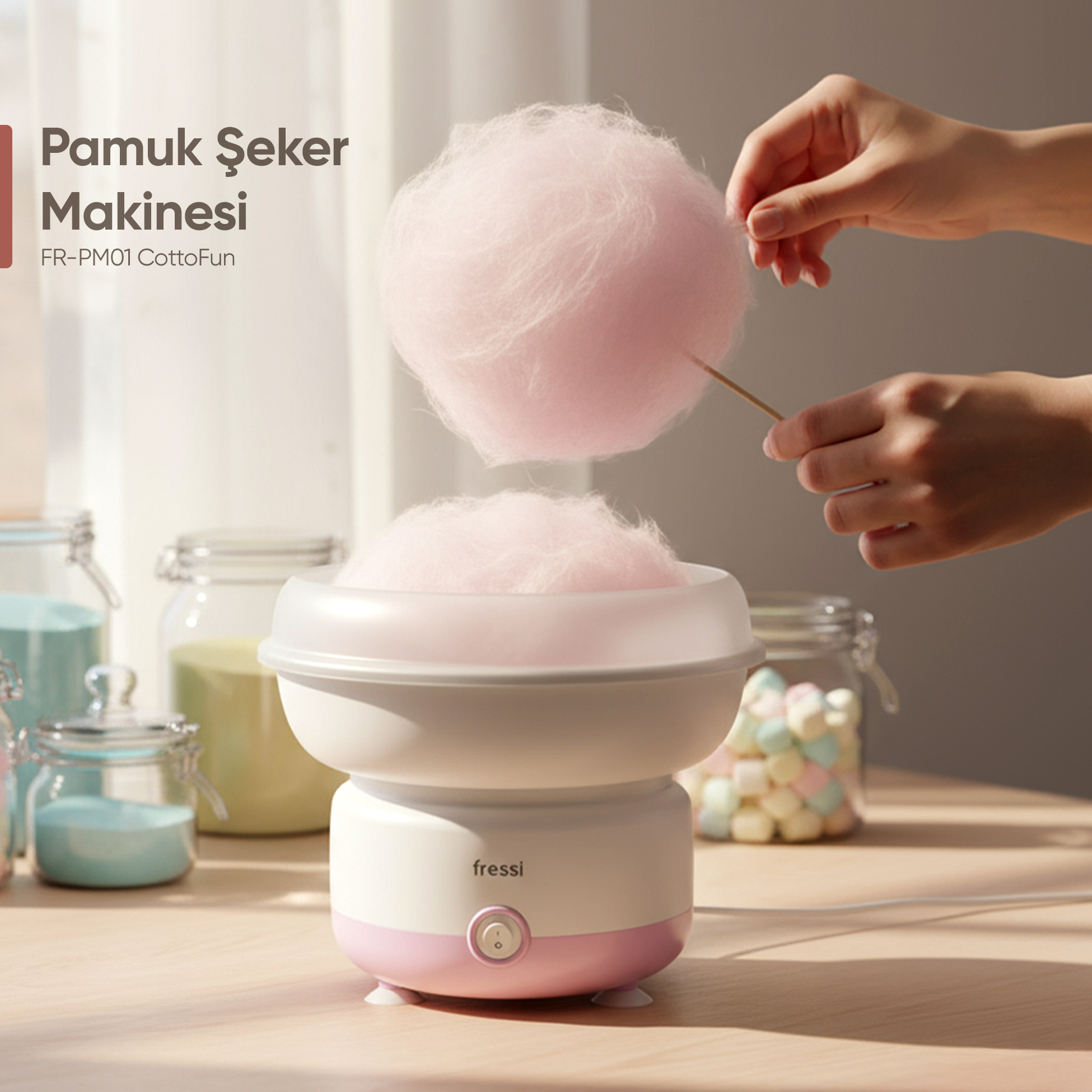 Pembe pamuk şeker bir el tarafından tahta çubukta tutuluyor.