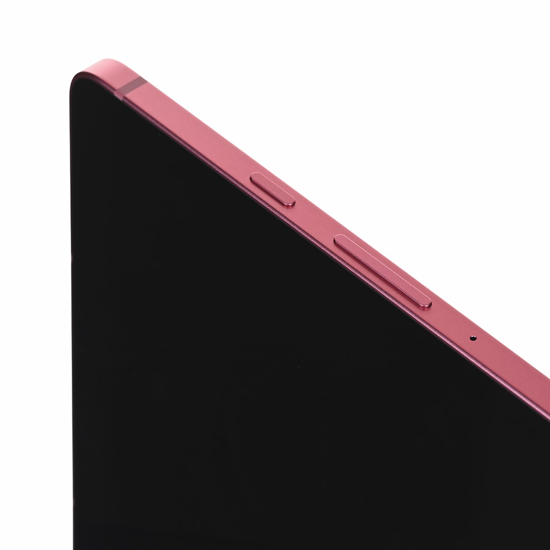Zbliżenie na różowy smartfon z czarnym ekranem i przyciskami.