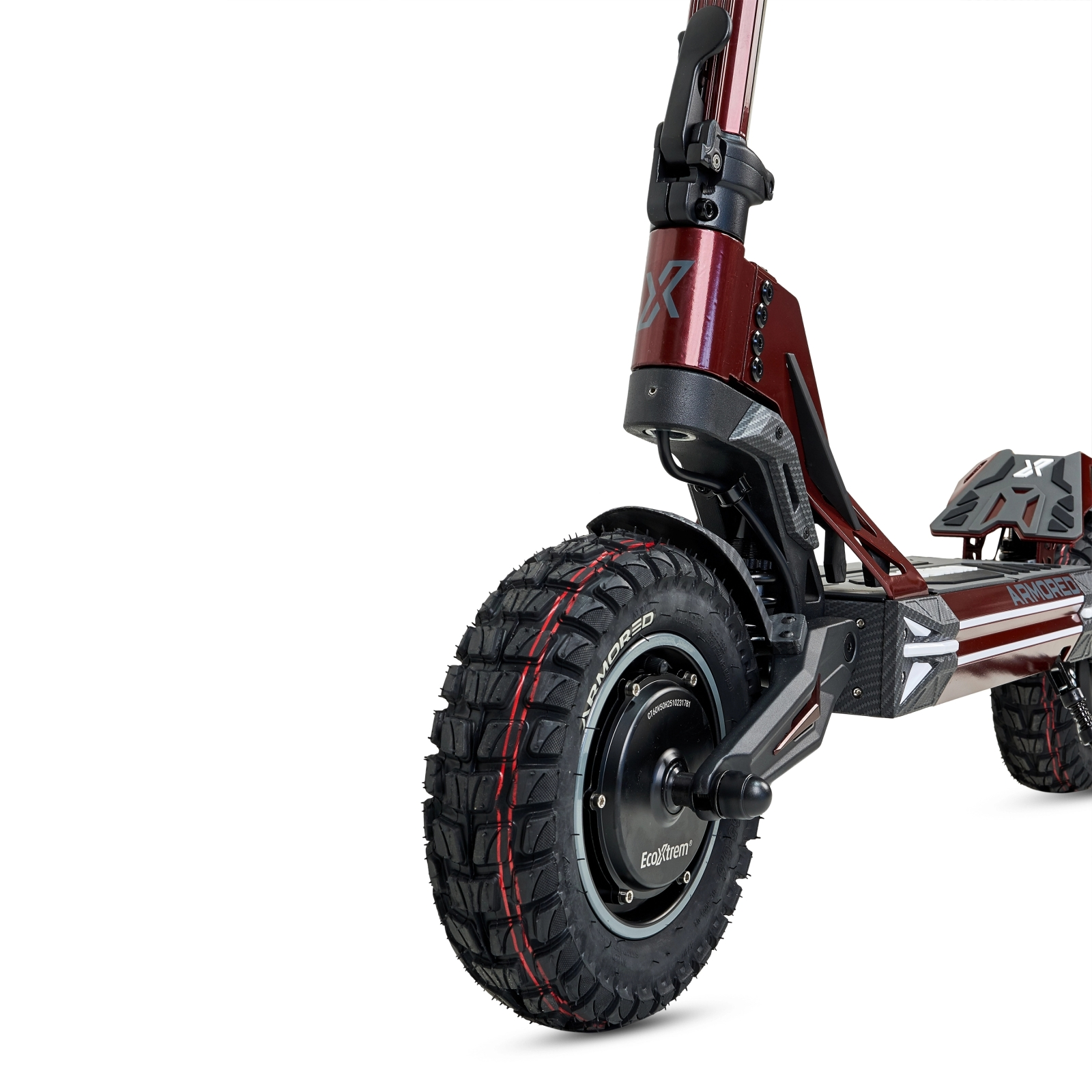 Primer plano de un patinete eléctrico rojo con neumático de tacos y motor visible.