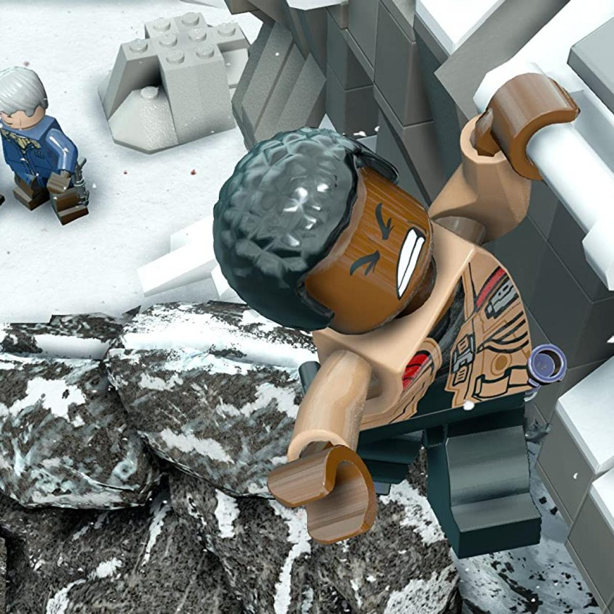 Figurka Lego wspina się po ośnieżonych skałach, w tle inna figurka.