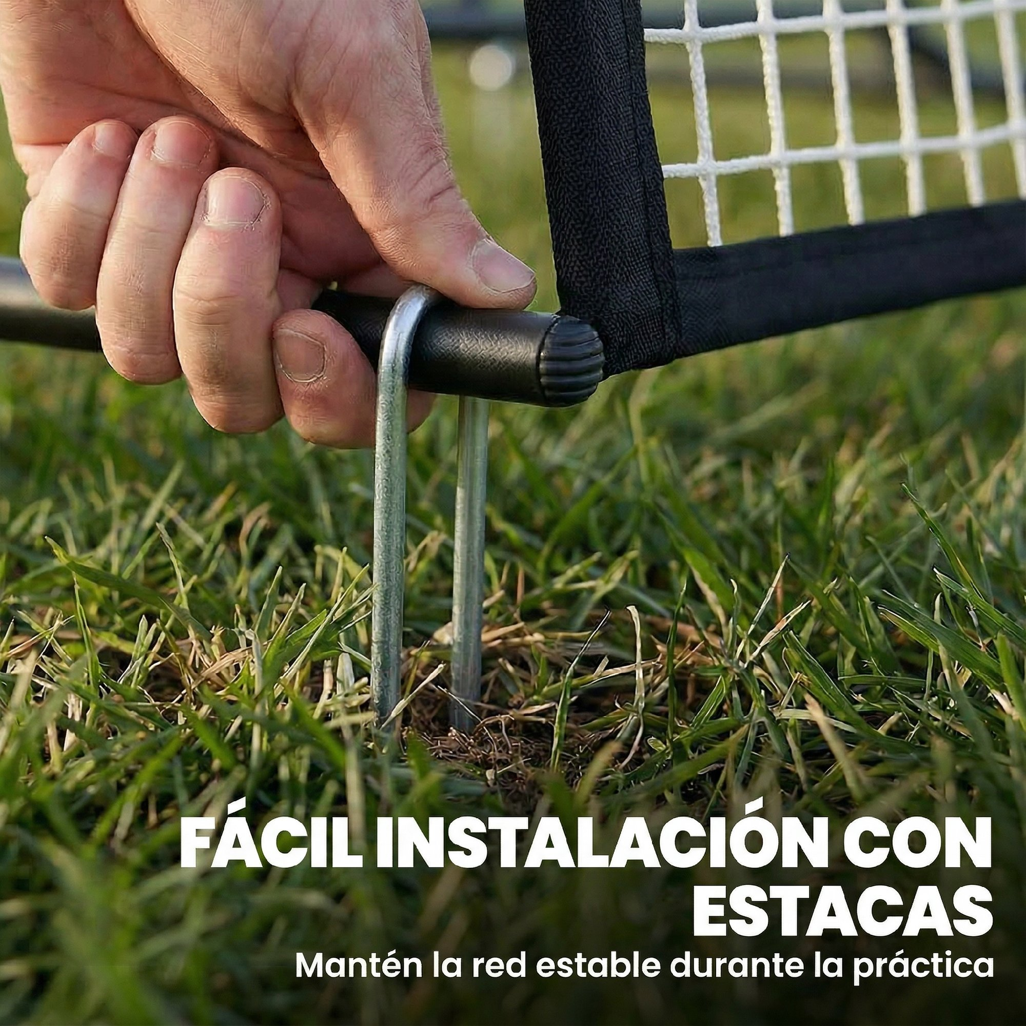 Una mano inserta una estaca de metal en el césped para asegurar una red.